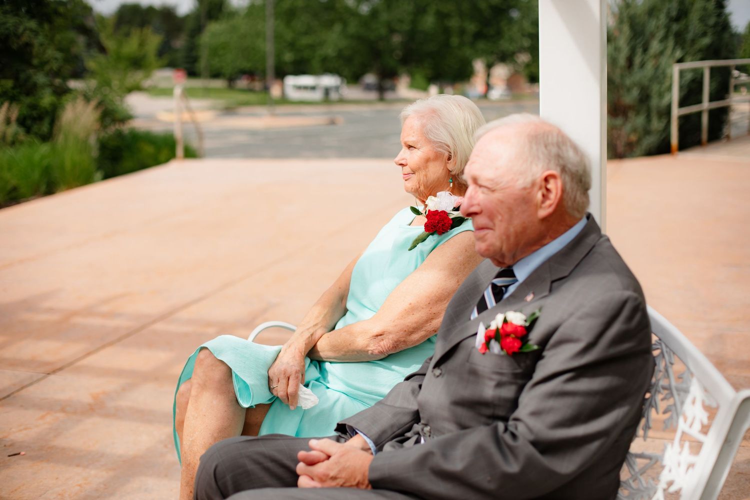 Wedding guests relax on outdoor patio seating during reception.