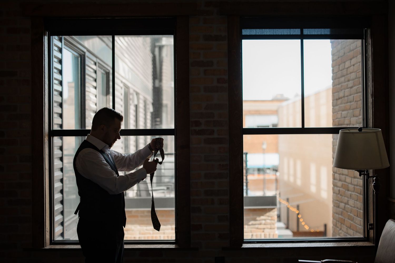 Silhouette by window of photographer taking pictures in urban setting.