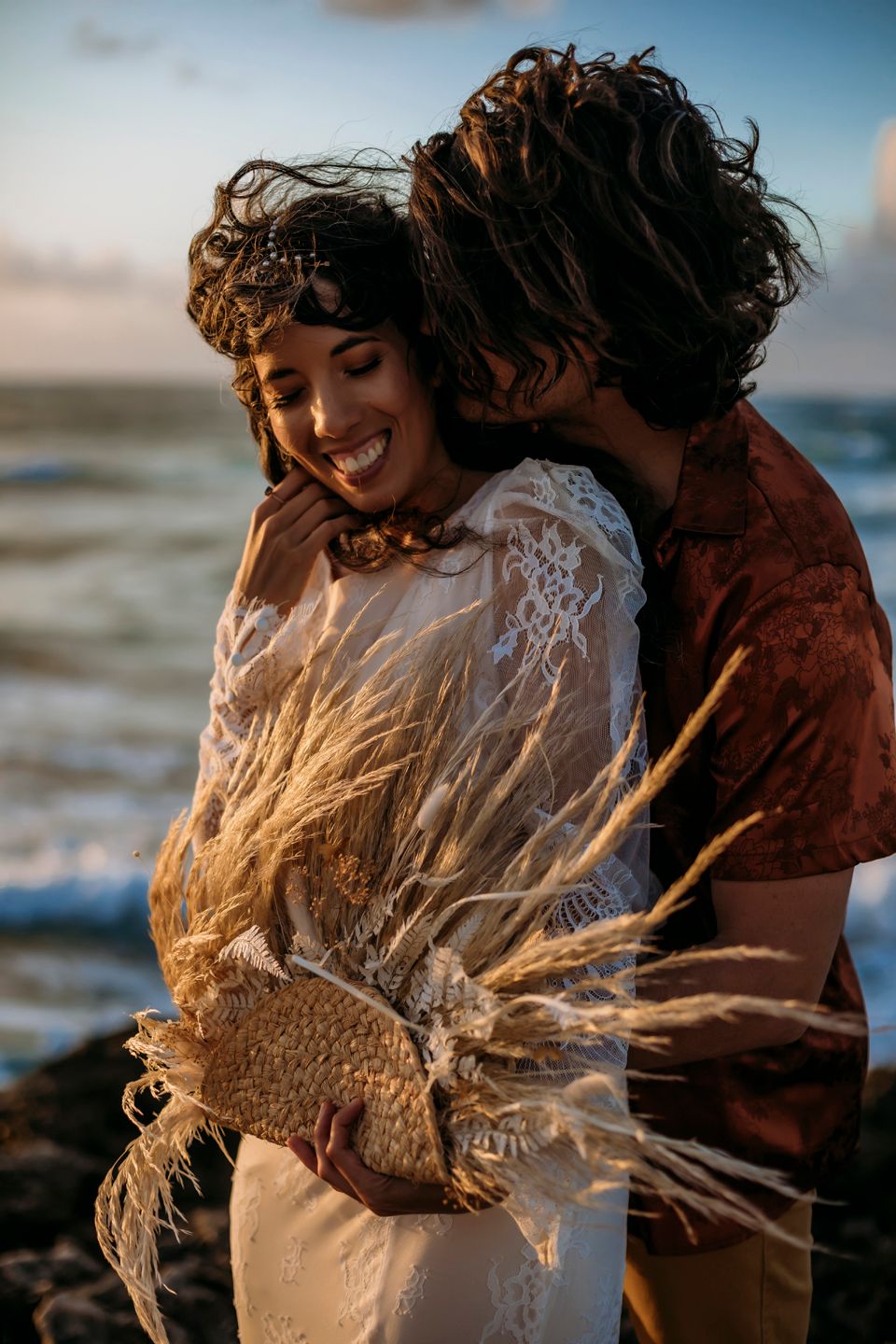 Intimate beachside moment with decorative dried pampas grass and lace wedding dress.