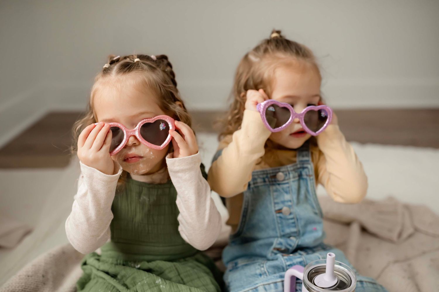 Six candid photos show children wearing sunglasses and making silly faces while playing together indoors.