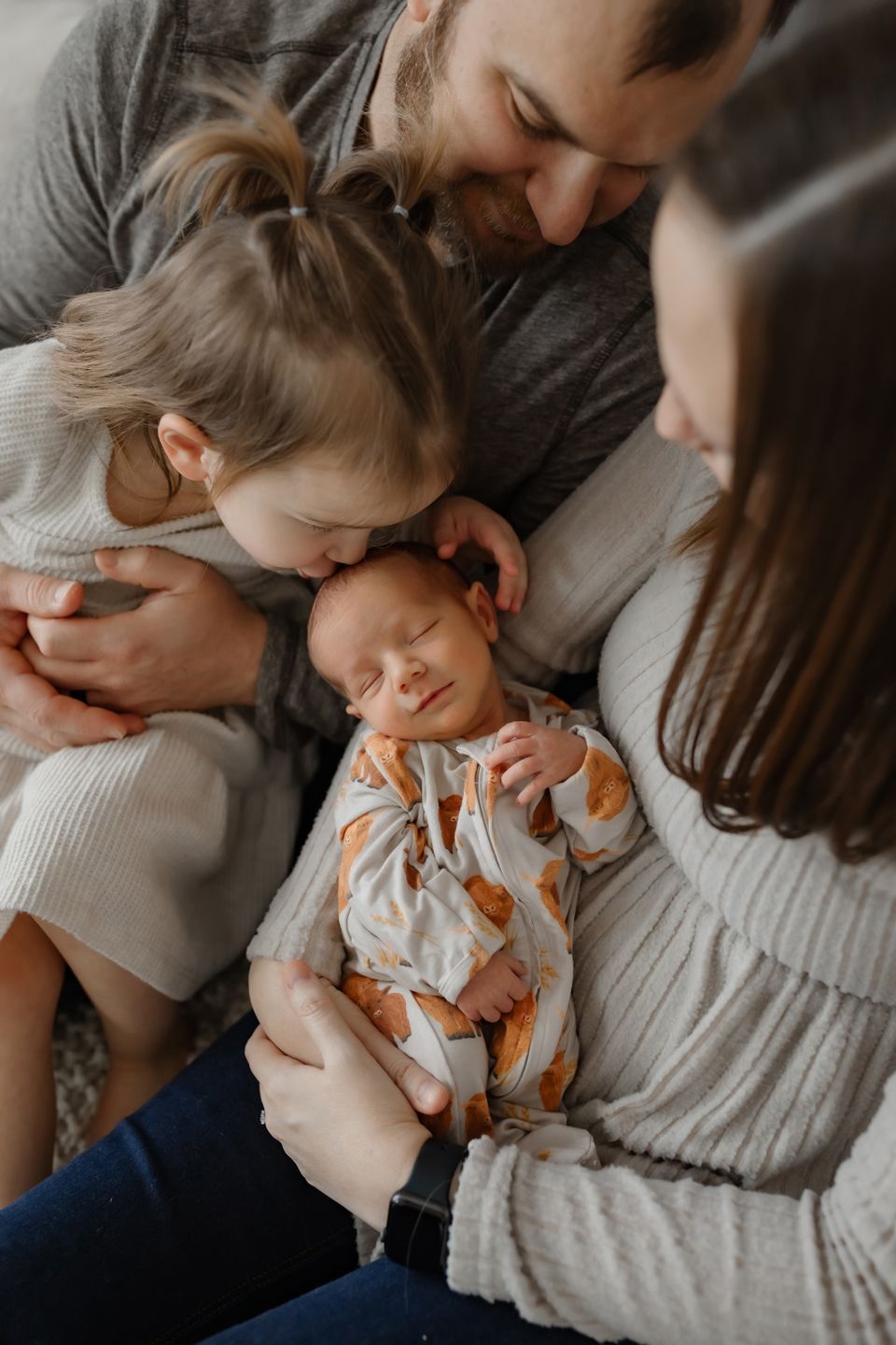 Intimate family moment showing parents and children cuddled together.
