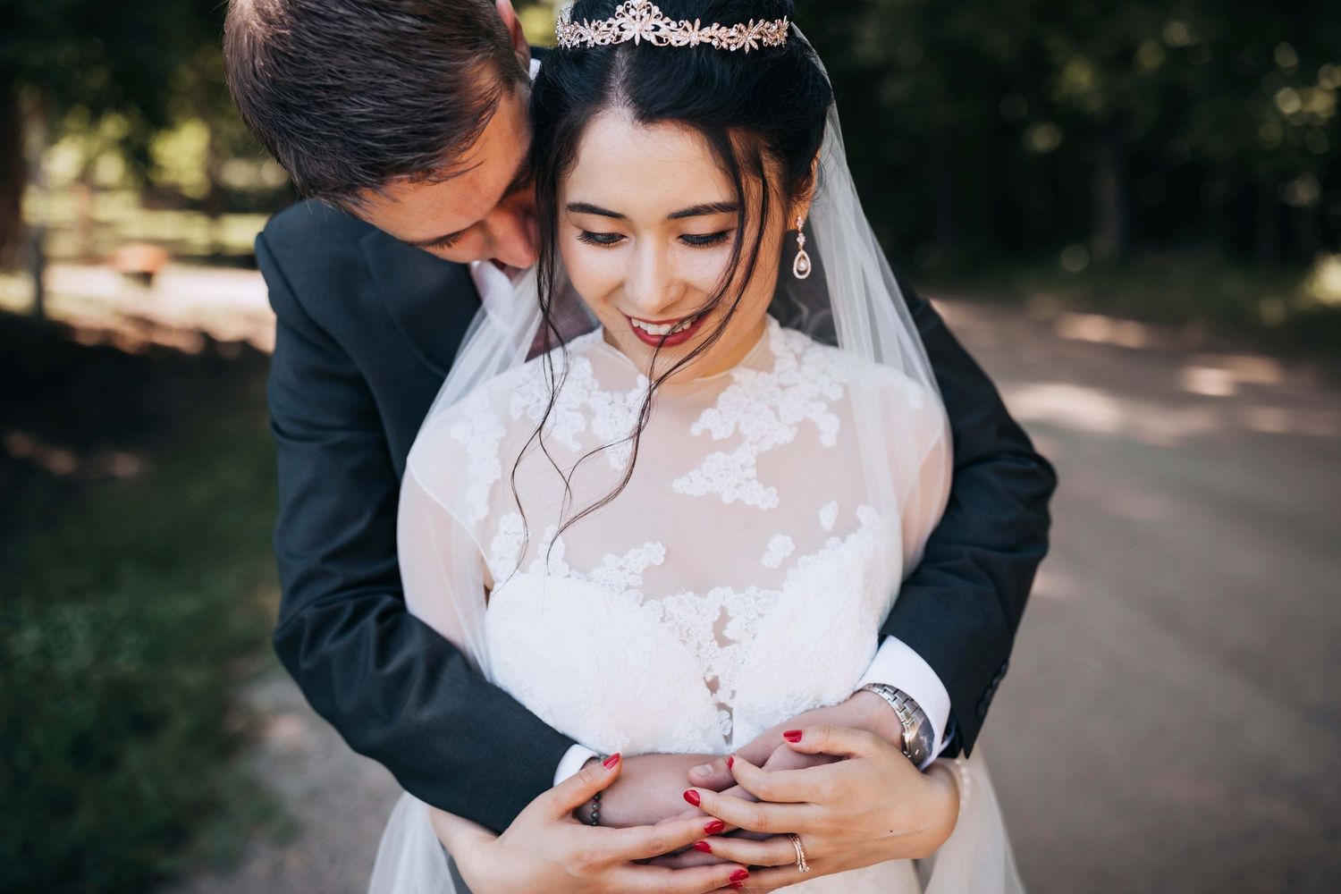 Romantic wedding embrace showing lace dress details and formal attire.