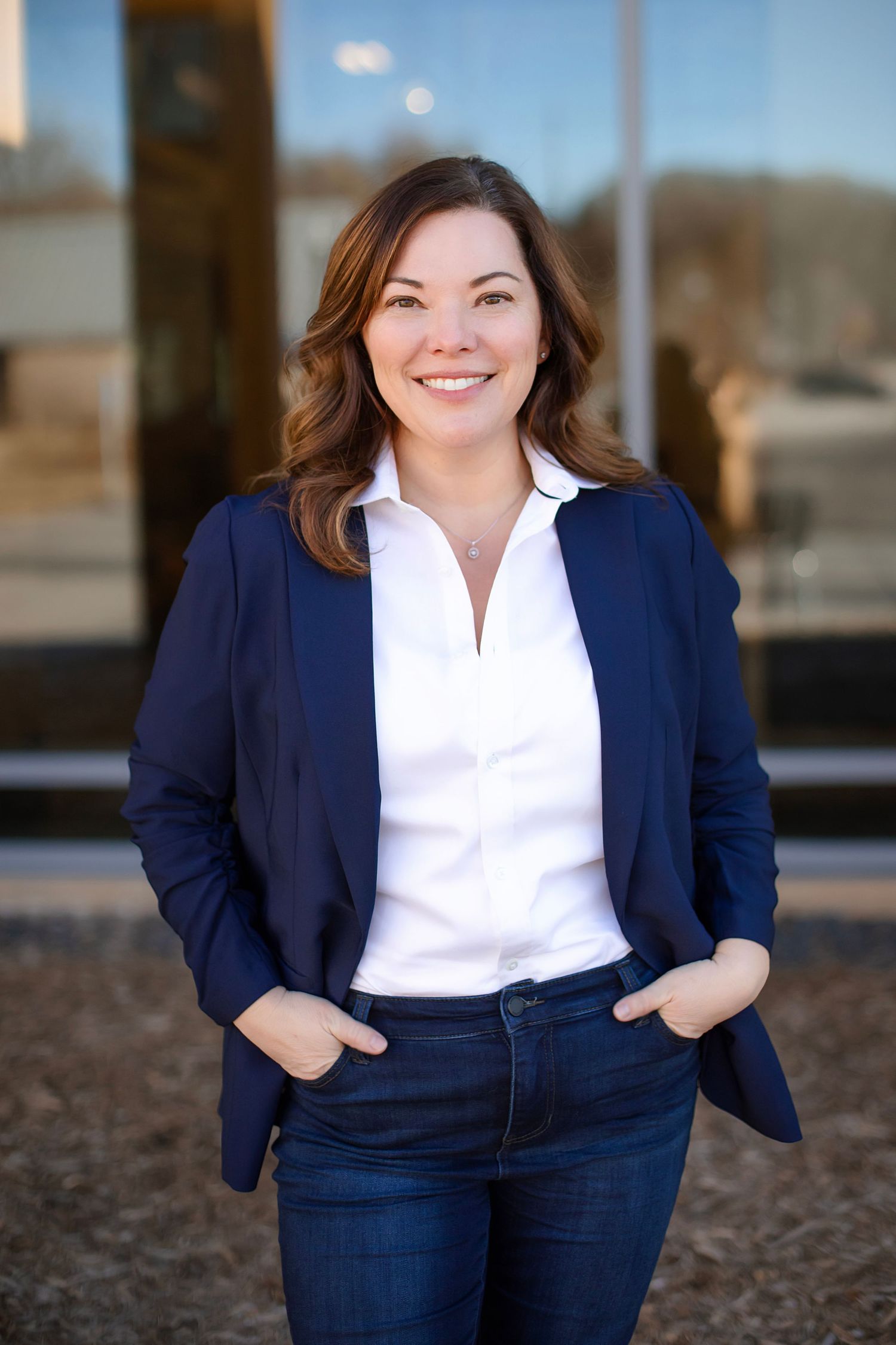 Professional outdoor portrait featuring navy blazer, white shirt and denim business casual look.