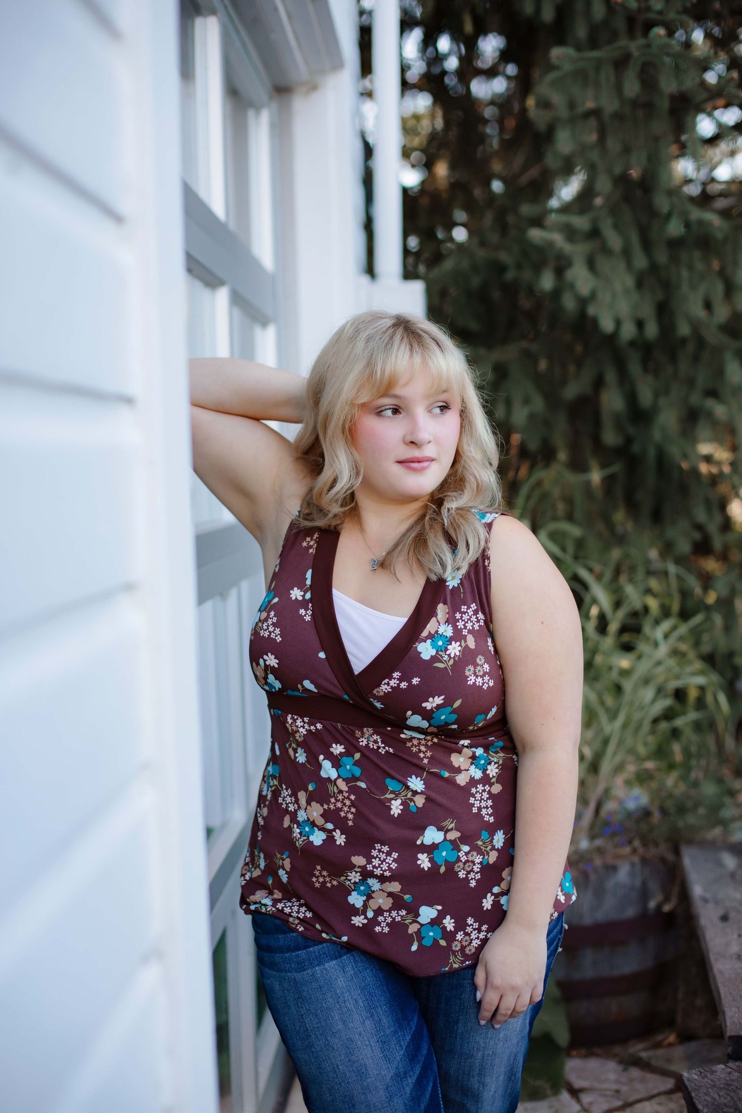 Casual portrait against white building exterior wall.