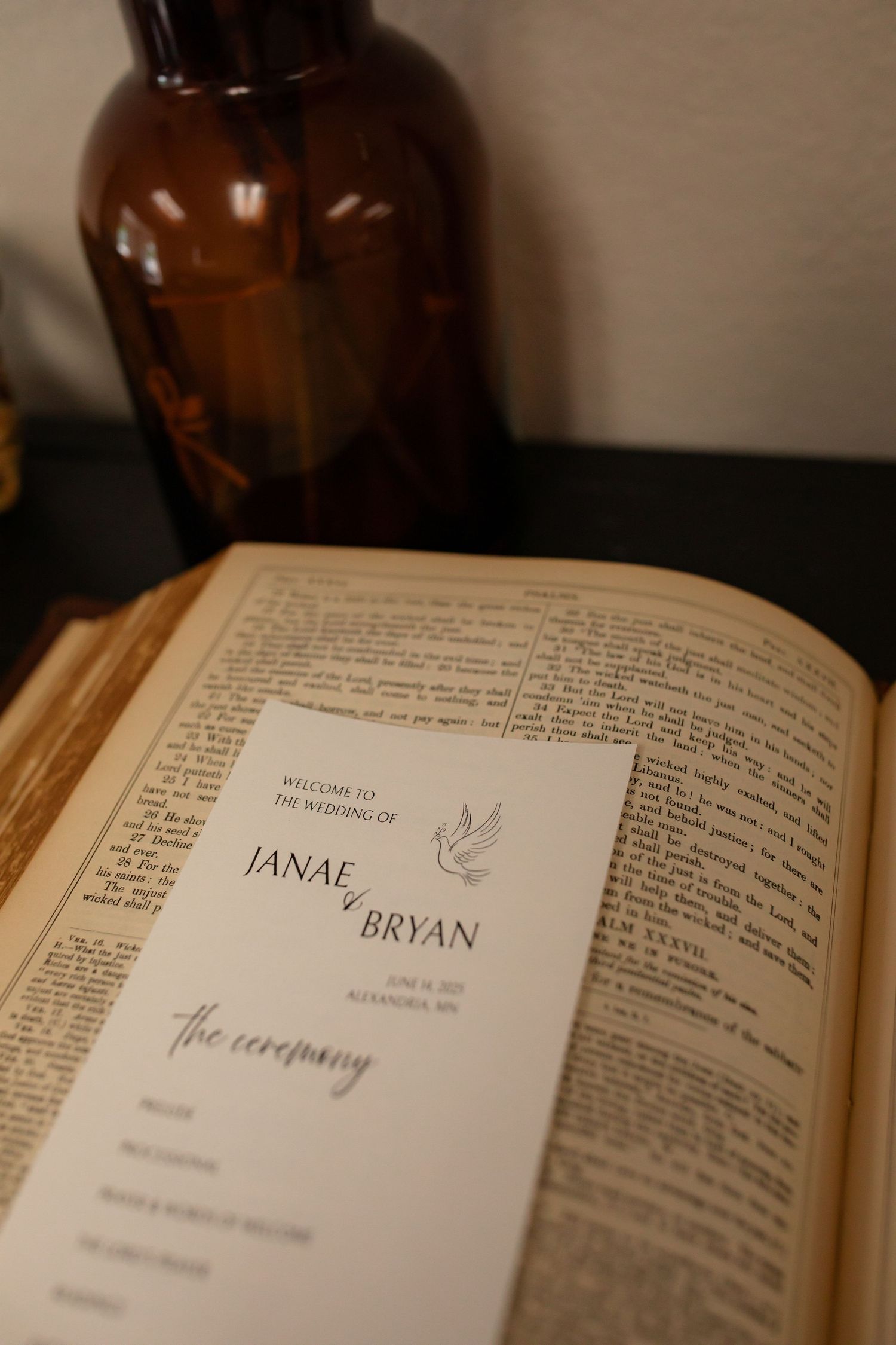 Open wedding program book showing names and ceremony details with a small dove illustration.