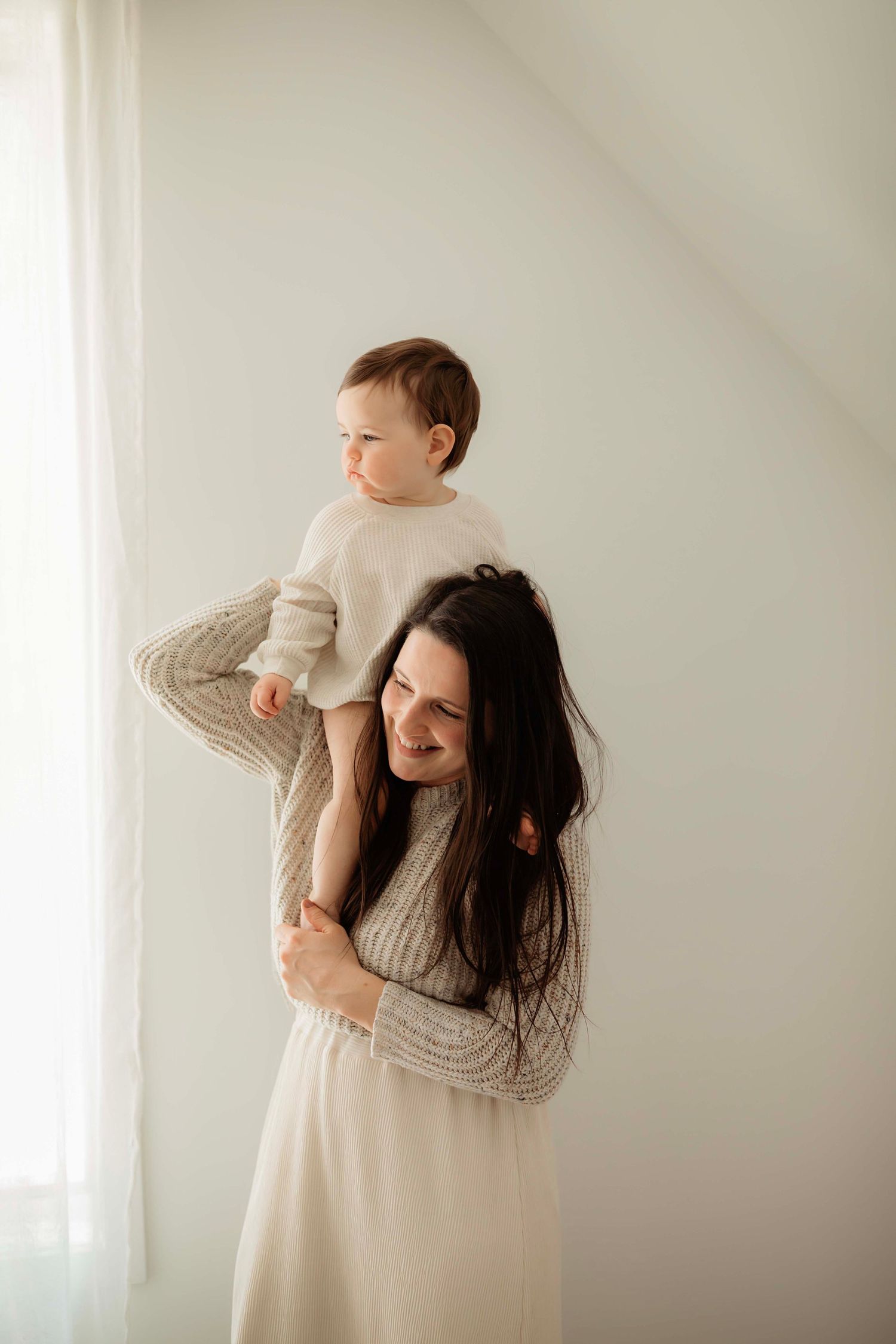 A series of soft, minimalist photos showing tender moments Willow & Wren Photography studio in Chaska Minnesota. Family portraits.