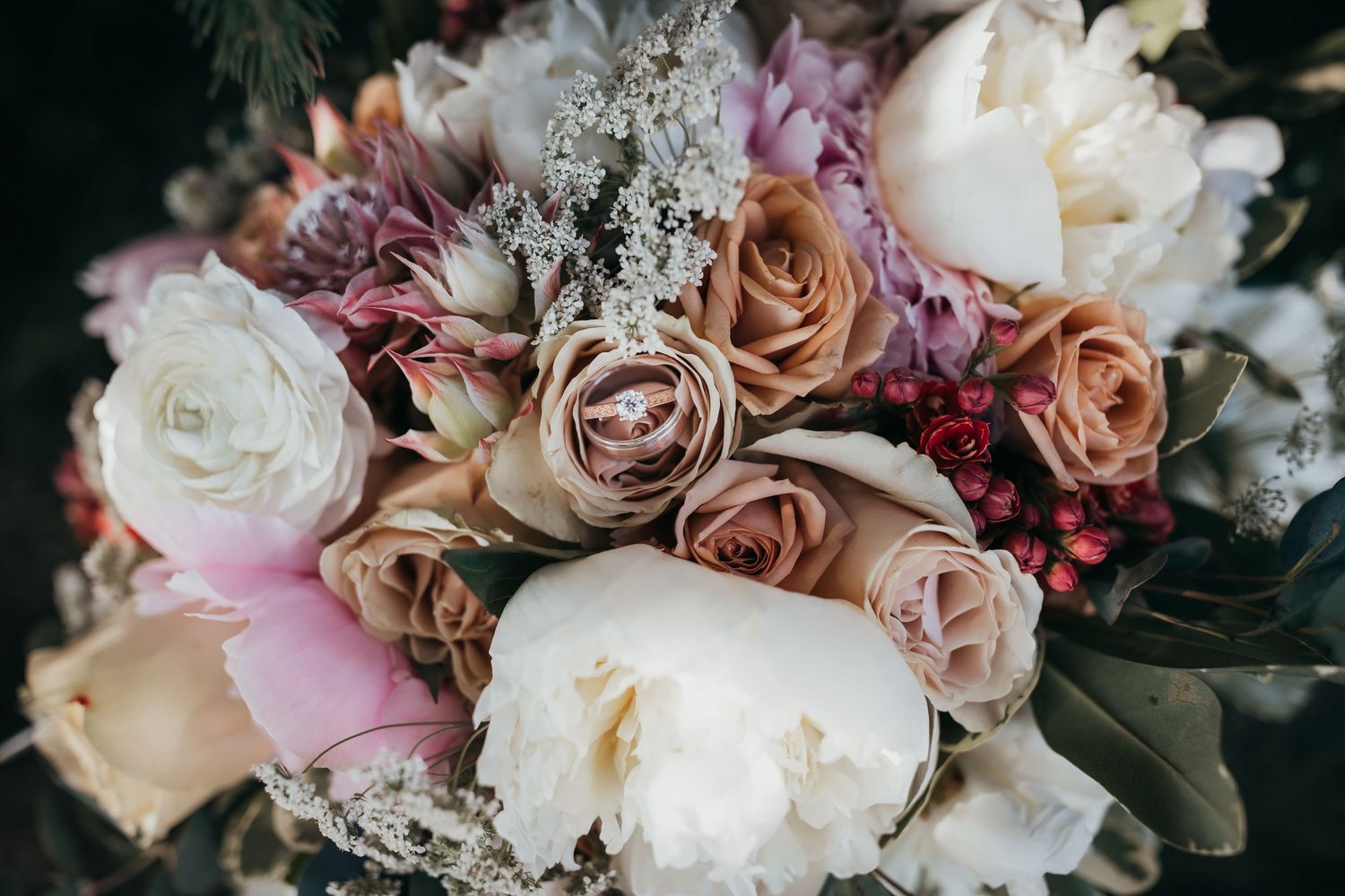 Close-up of romantic wedding bouquet with pink and white roses and mixed flowers.