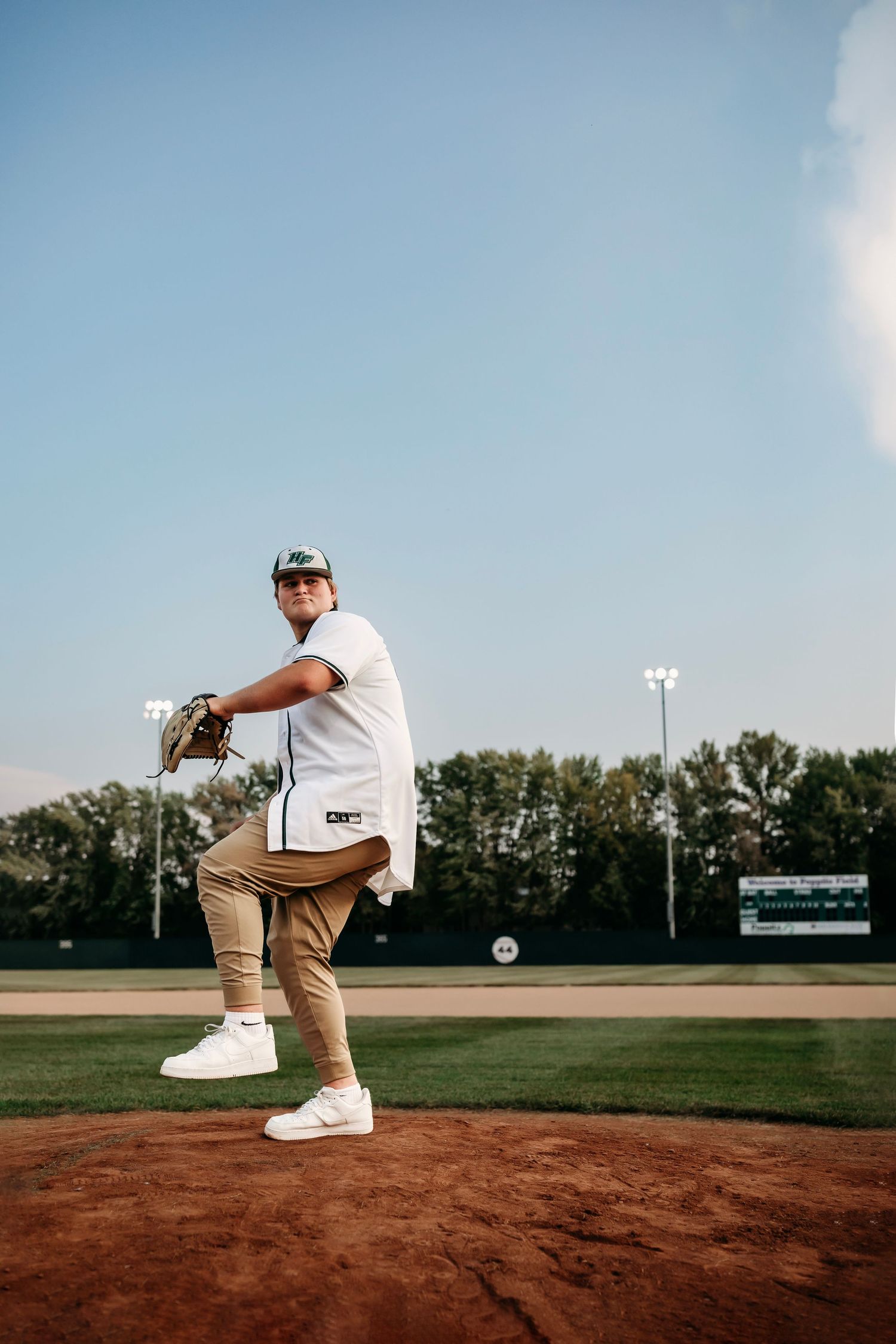 Baseball player in pitching motion demonstrates windup on pitcher's mound.