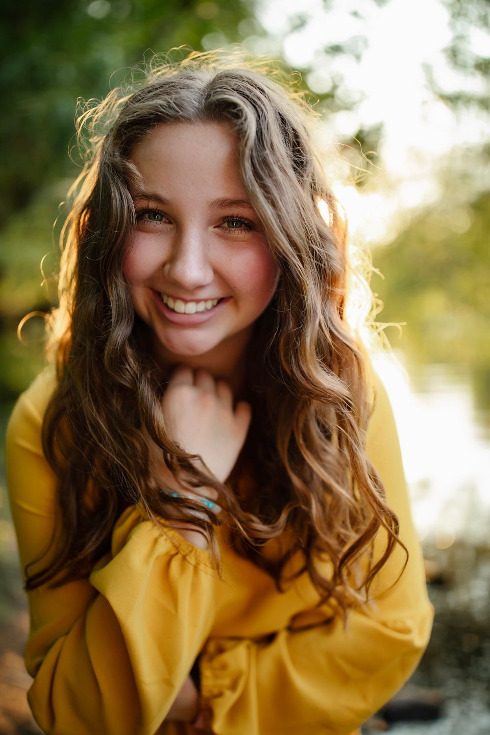 Close-up portrait in yellow sweater with backlit natural lighting.