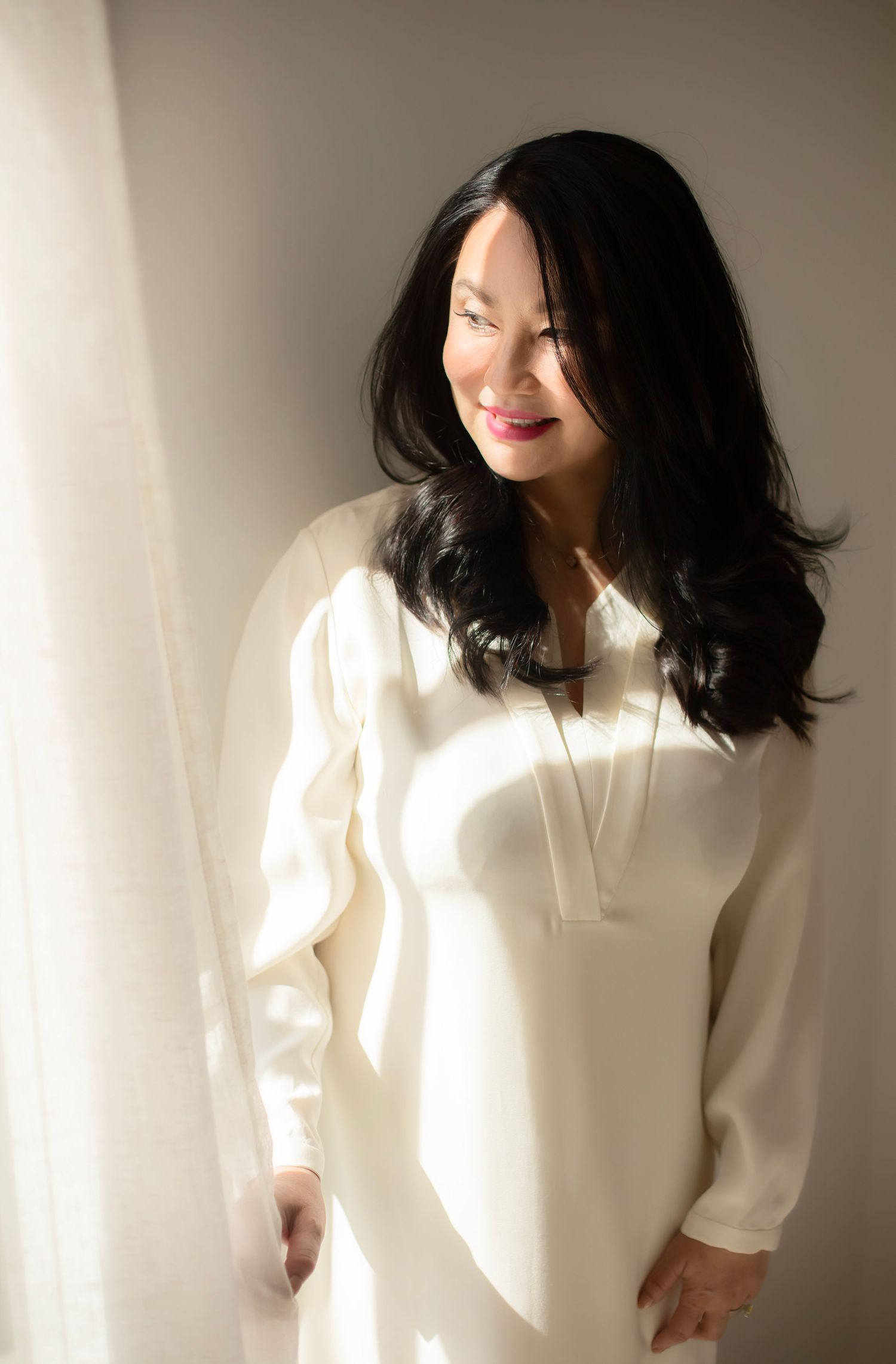 Artistic fashion portraits in a cream sweater with dramatic shadows and natural lighting.