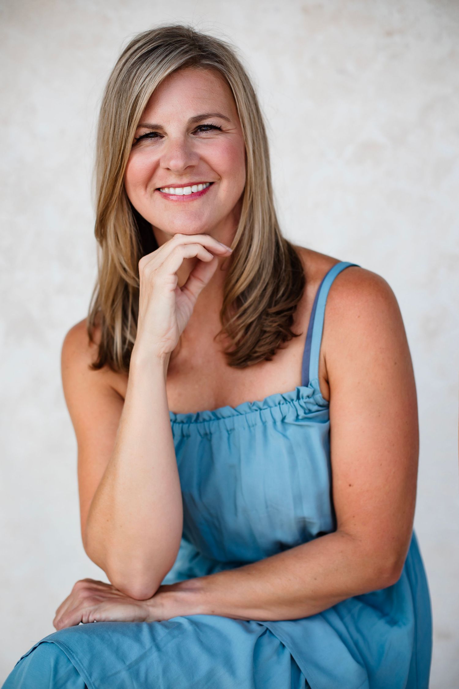 Candid portrait of someone in blue sundress with natural pose and genuine smile.