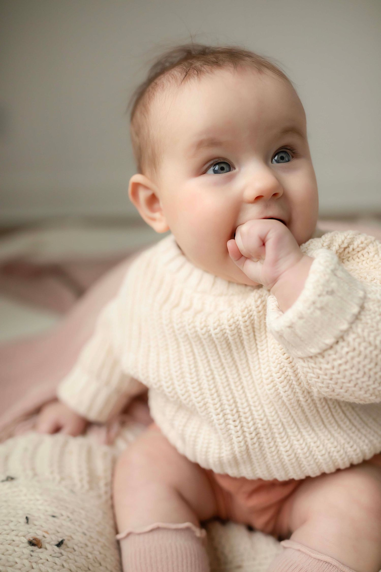 A baby wearing a cream knit sweater with Willow & Wren Photography