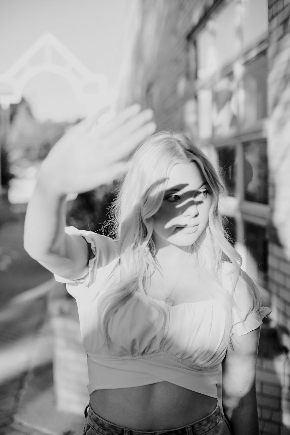 Black and white portrait with playful hand gestures and natural motion blur.