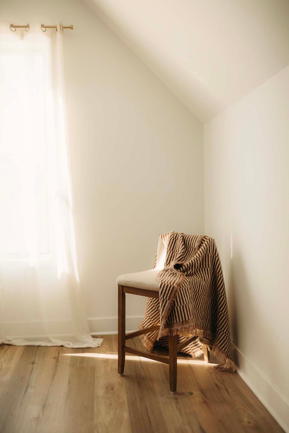Multiple views of a wooden chair with striped fabric against a white wall in natural lighting.