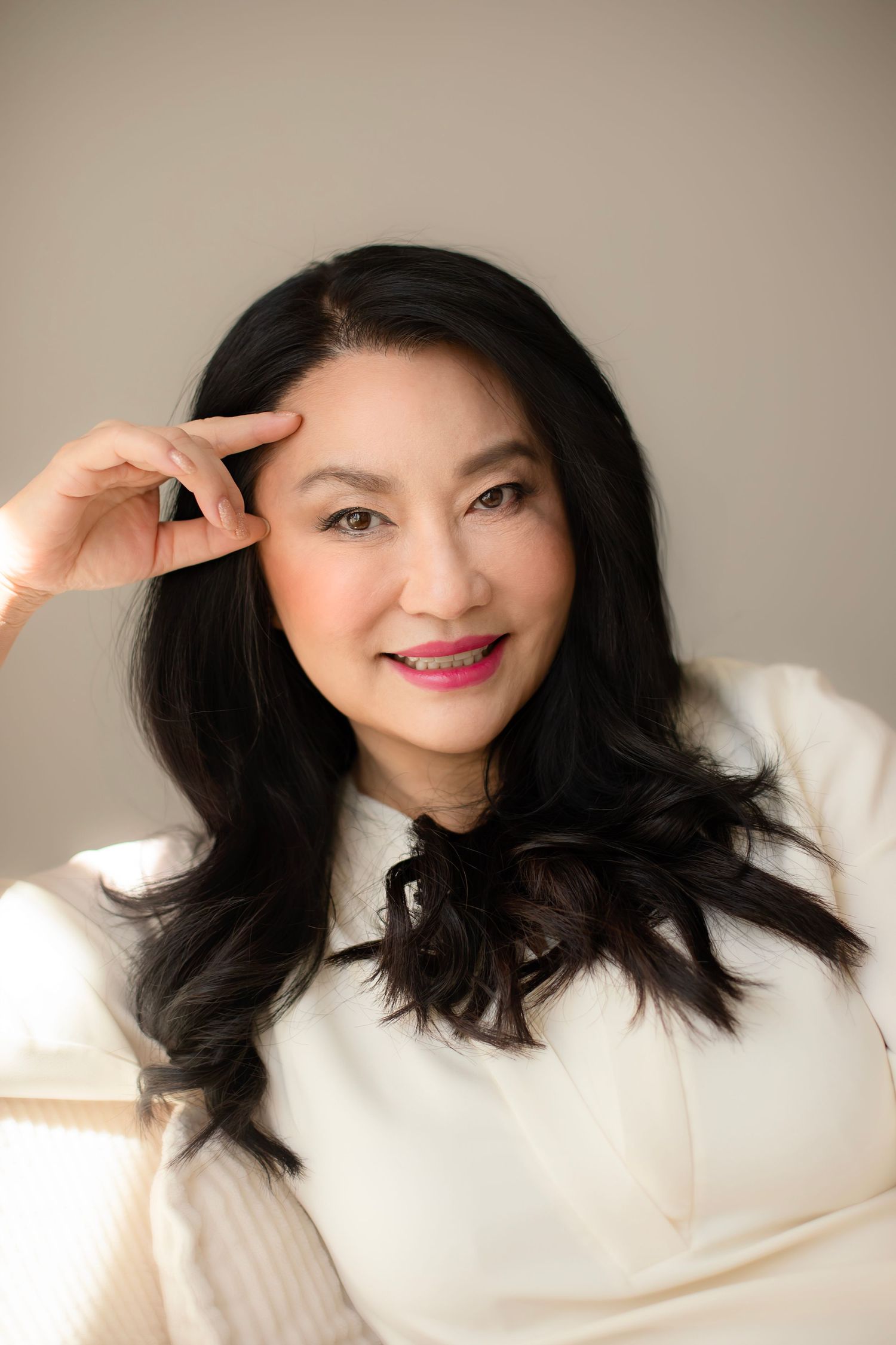 A series of headshots showing a person in a white sweater with dark hair against a neutral background.