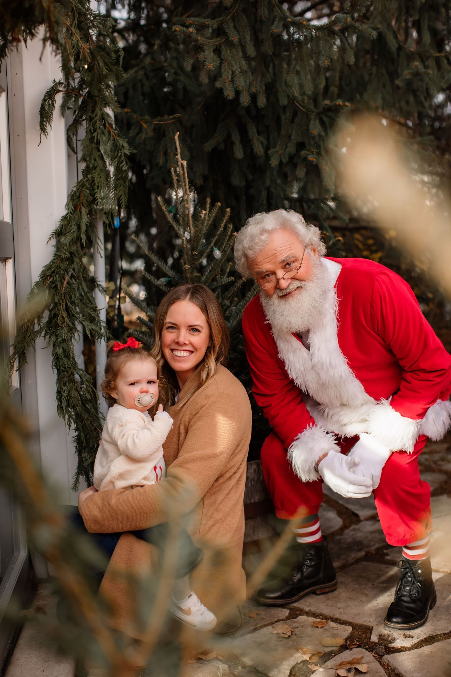 Holiday scene with evergreen decorations and seasonal attire.