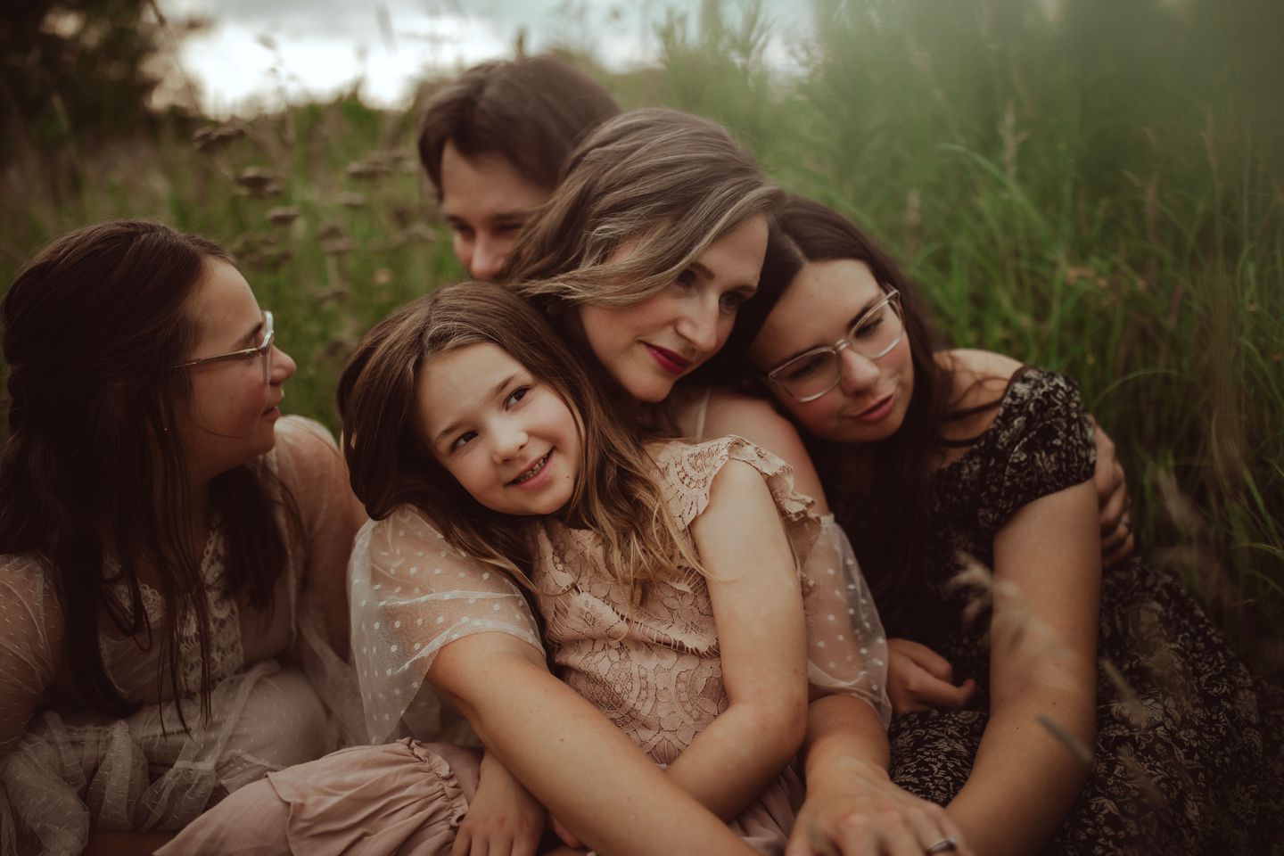 Group sharing joyful moment together in field during golden hour.