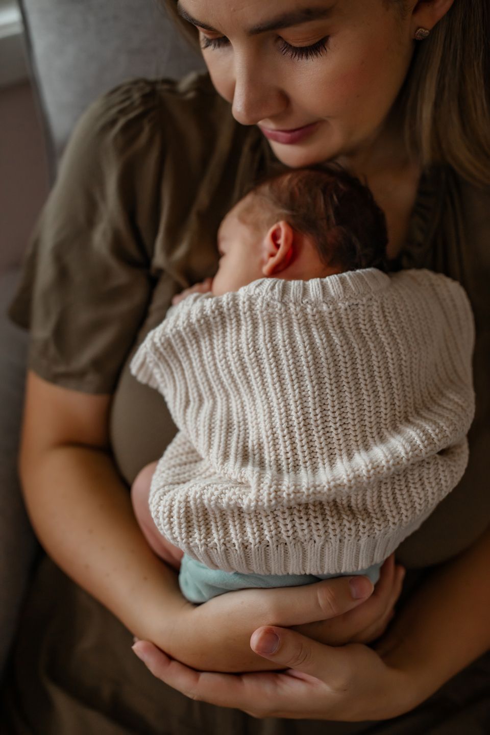 A tender embrace in a nursery featuring warm earth tones and soft knit textures.