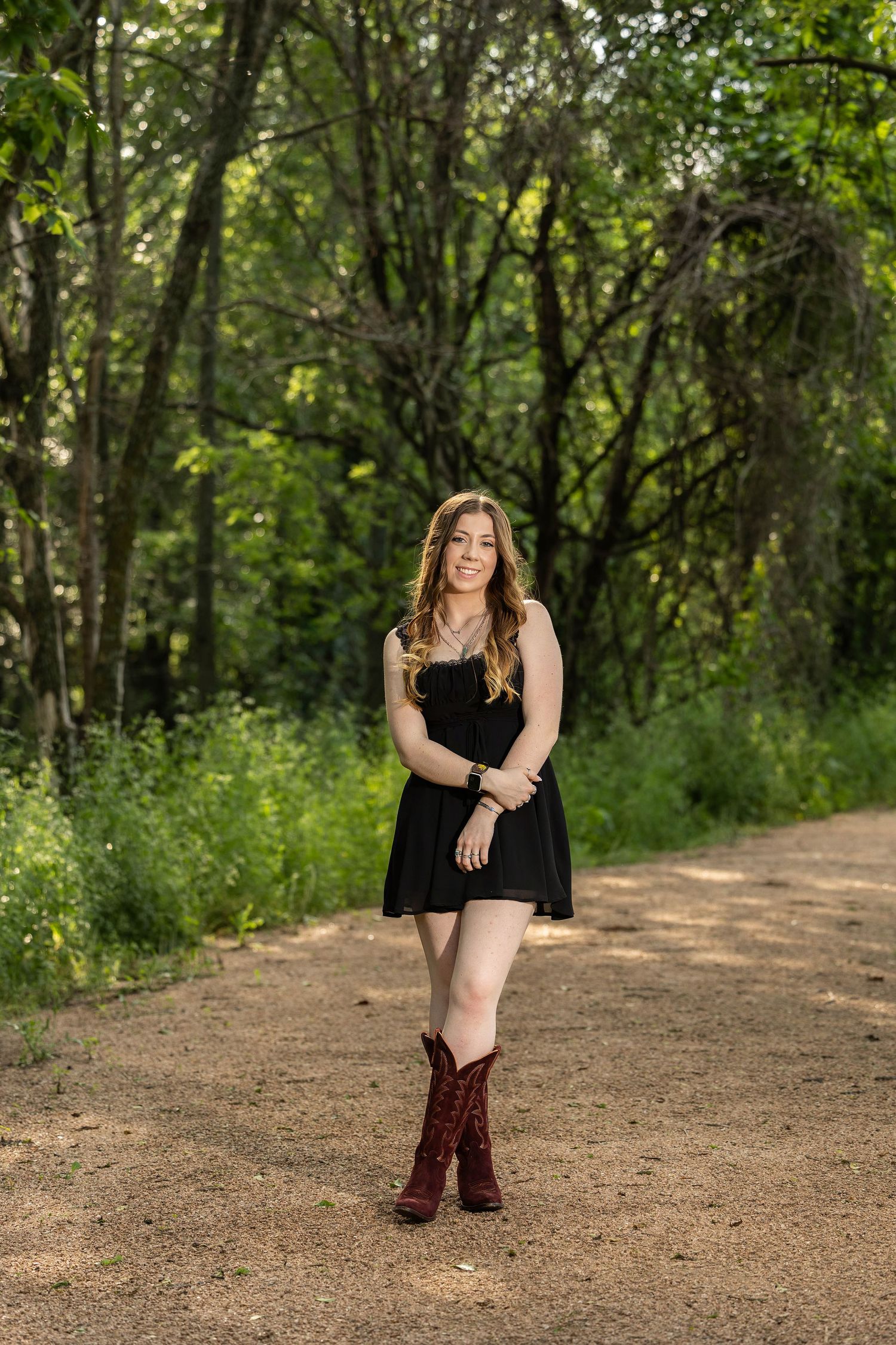 Black dress and burgundy boots create contrast on a nature trail photo shoot.