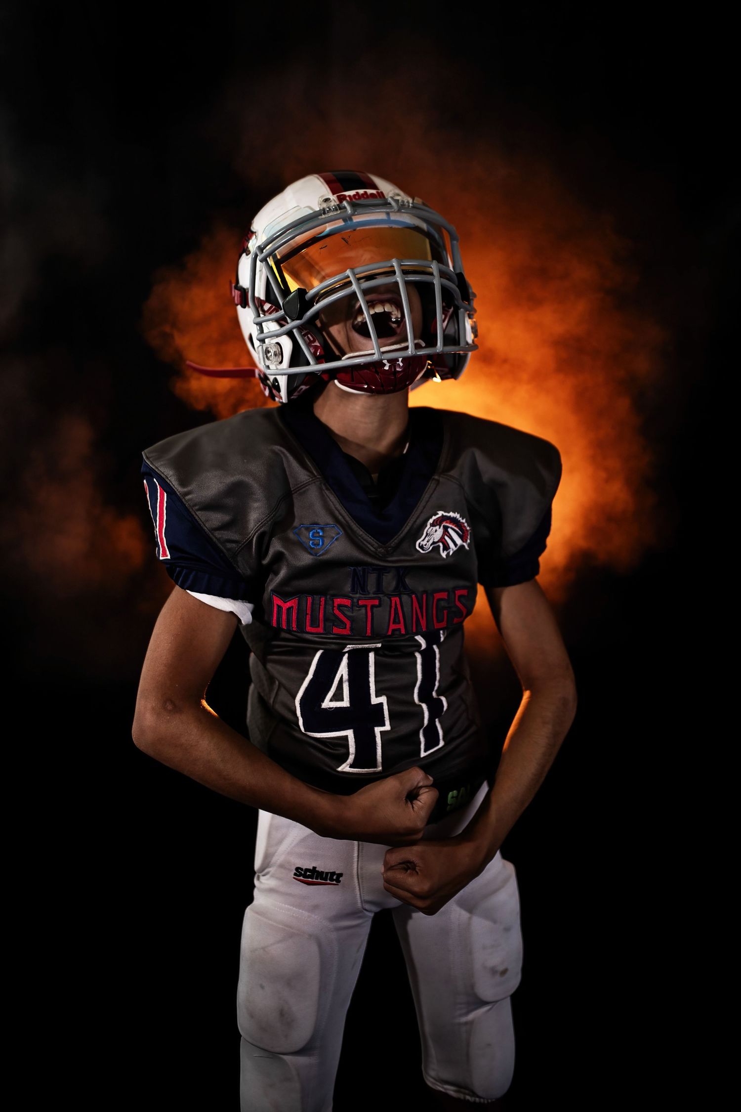 A football player wearing a Mustang jersey number 41 poses against a fiery orange background.