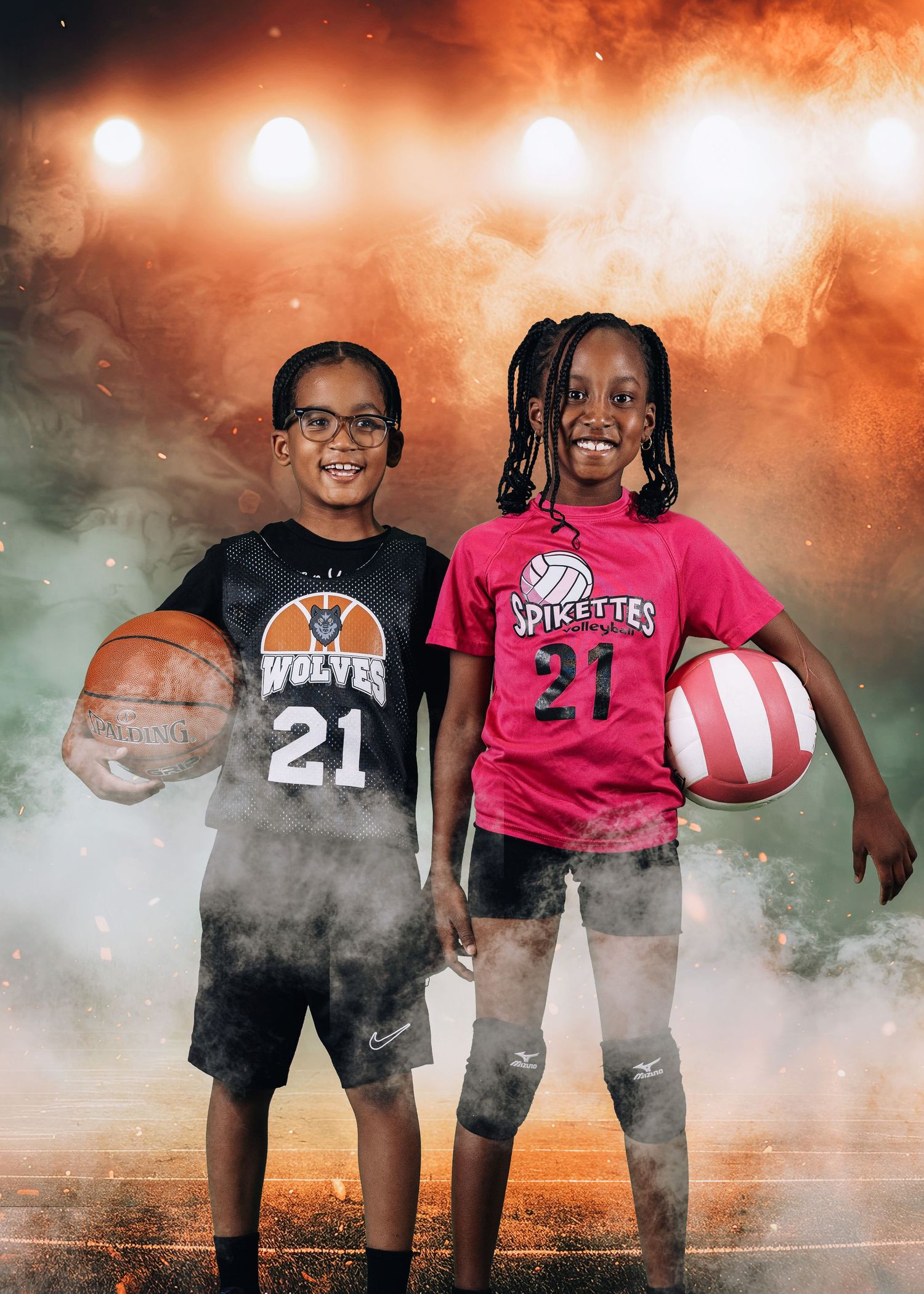 Two young athletes holding basketballs stand side by side in sports jerseys against a dramatic backlit background with fog effects.