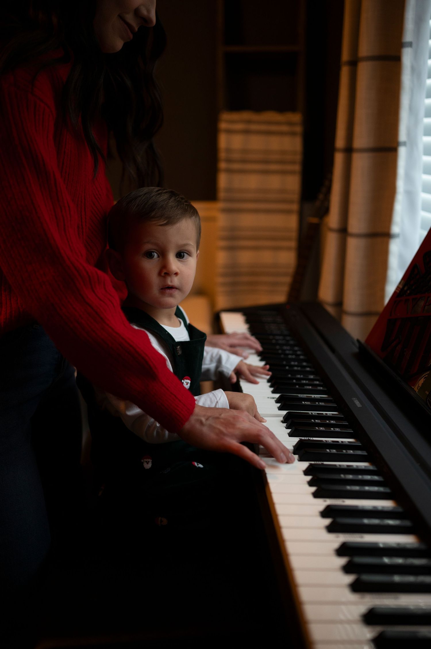 A piano lesson in progress with hands on the keys in warm lighting.