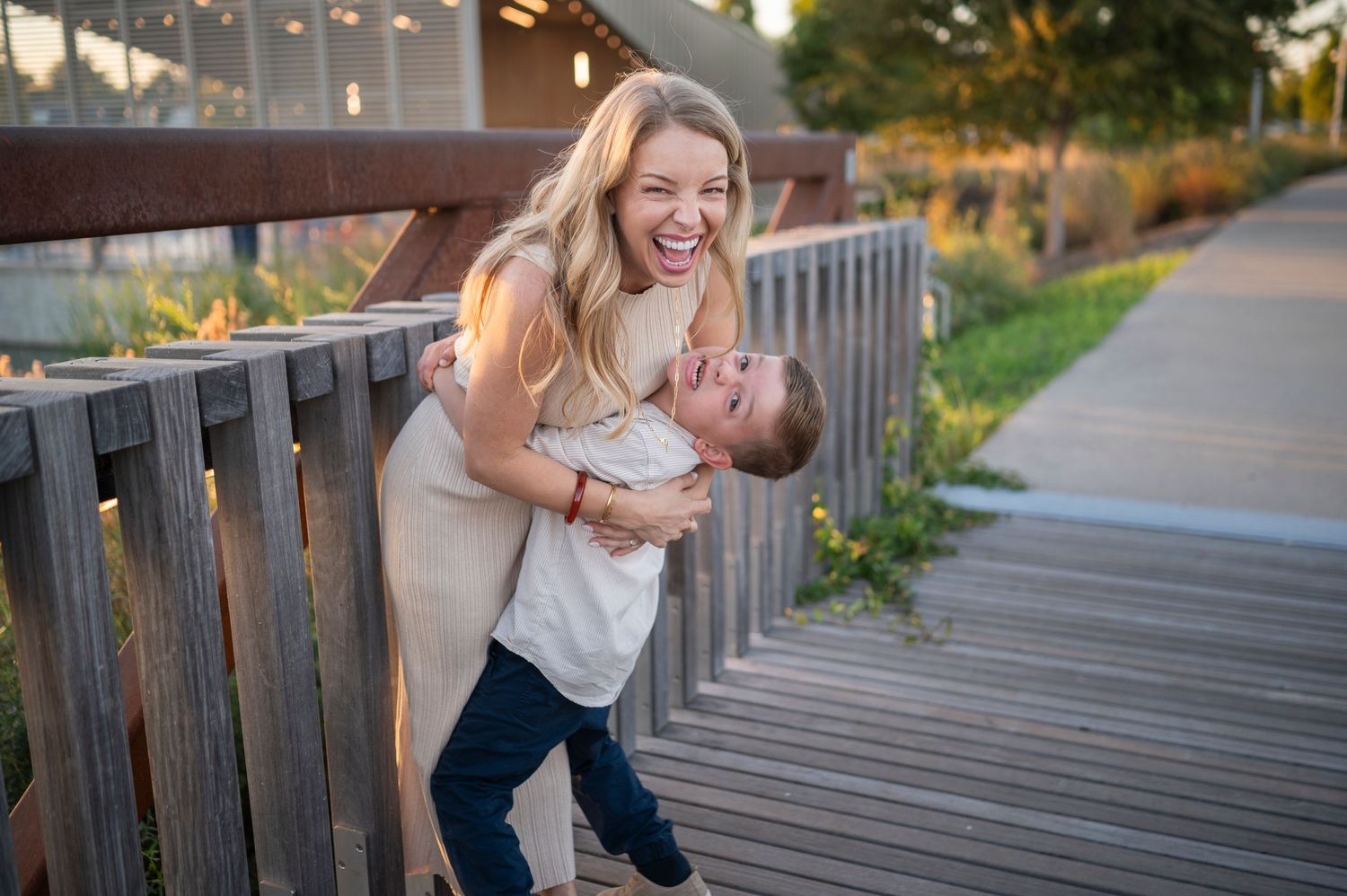 Playful moment on wooden deck with railing against natural outdoor backdrop.