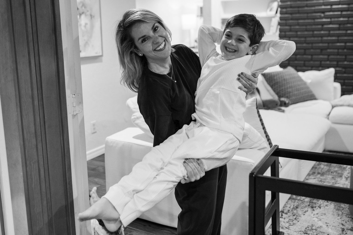 Two people share a playful moment on furniture in a casual home setting.