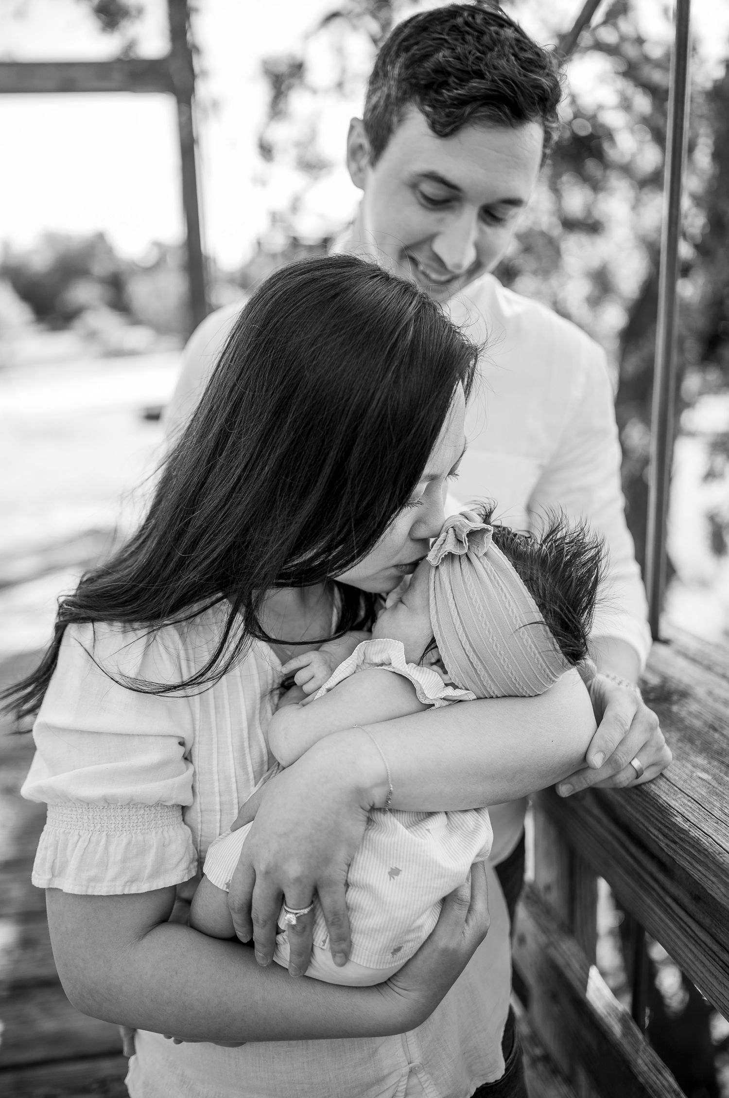 Black and white photo series showing intimate family moments seated on an outdoor bench.