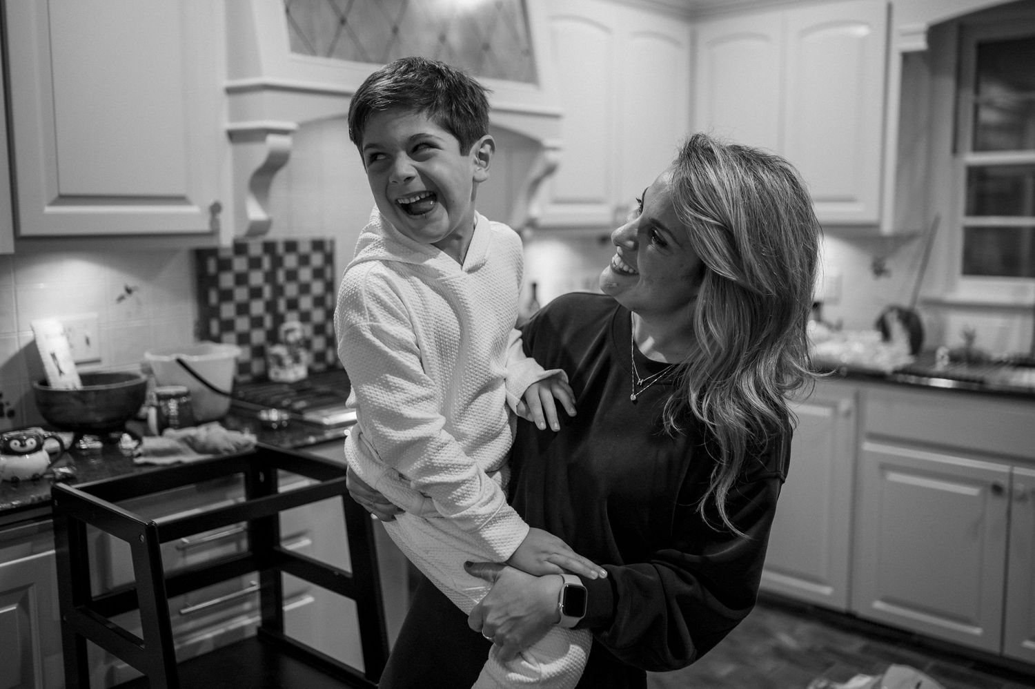 A joyful black and white moment captured in a bright modern kitchen.