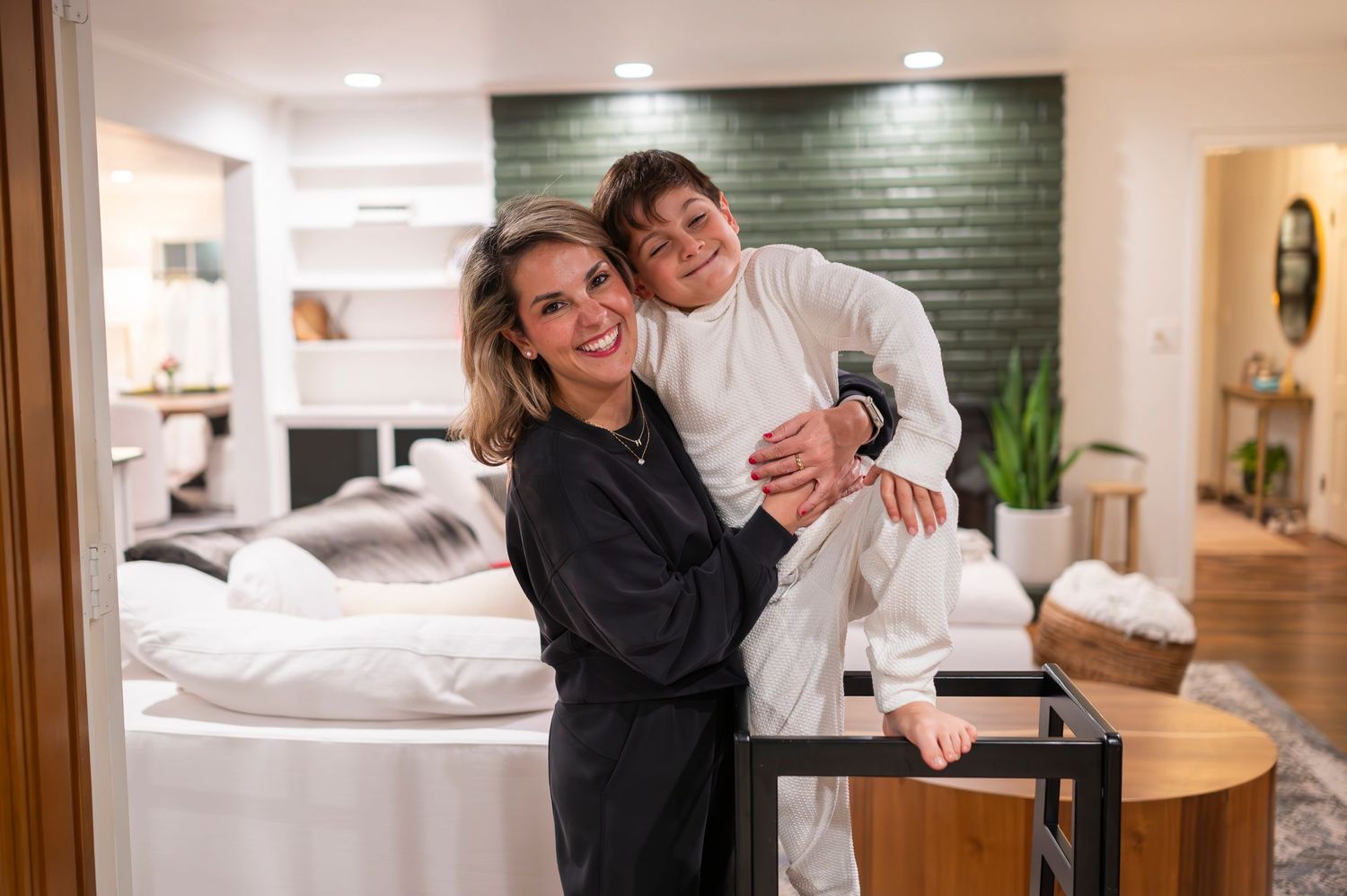 A heartwarming moment of laughter and embrace in a modern home setting.