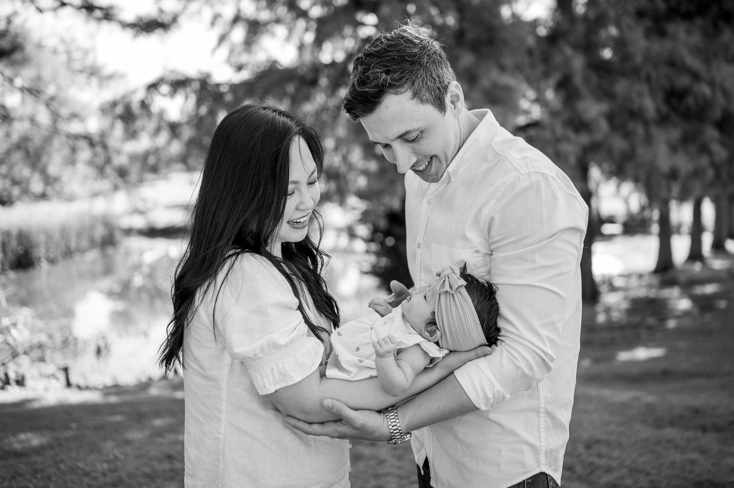 A couple shares tender romantic moments in black and white photos at an outdoor park setting.