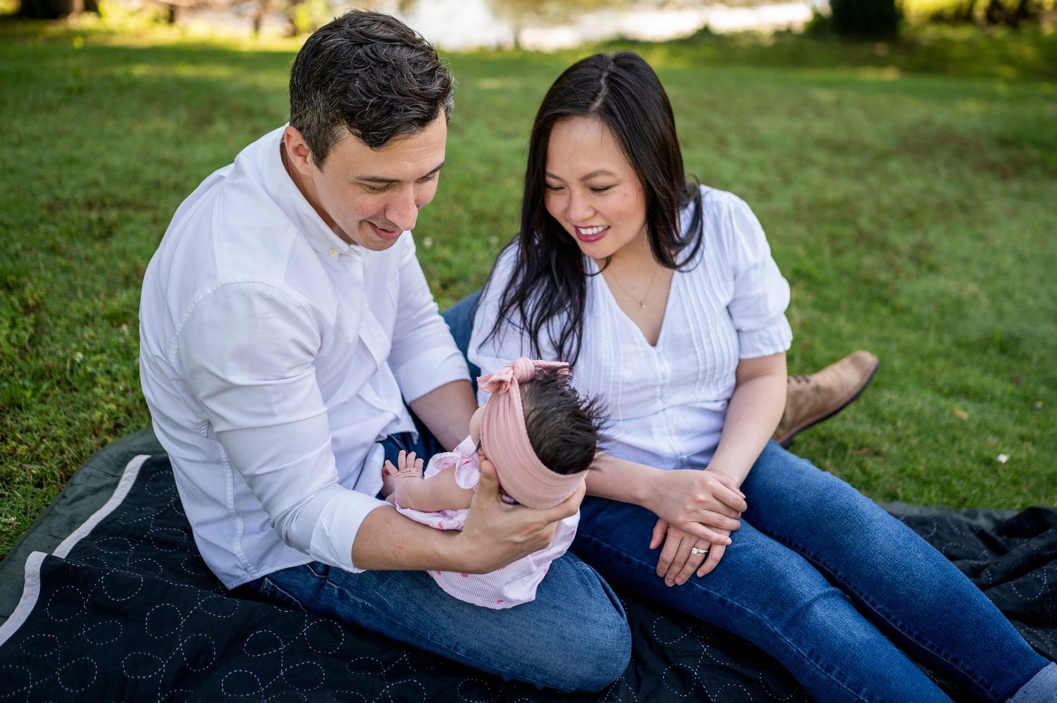 Happy family sitting in a sunlit park together on a beautiful day.