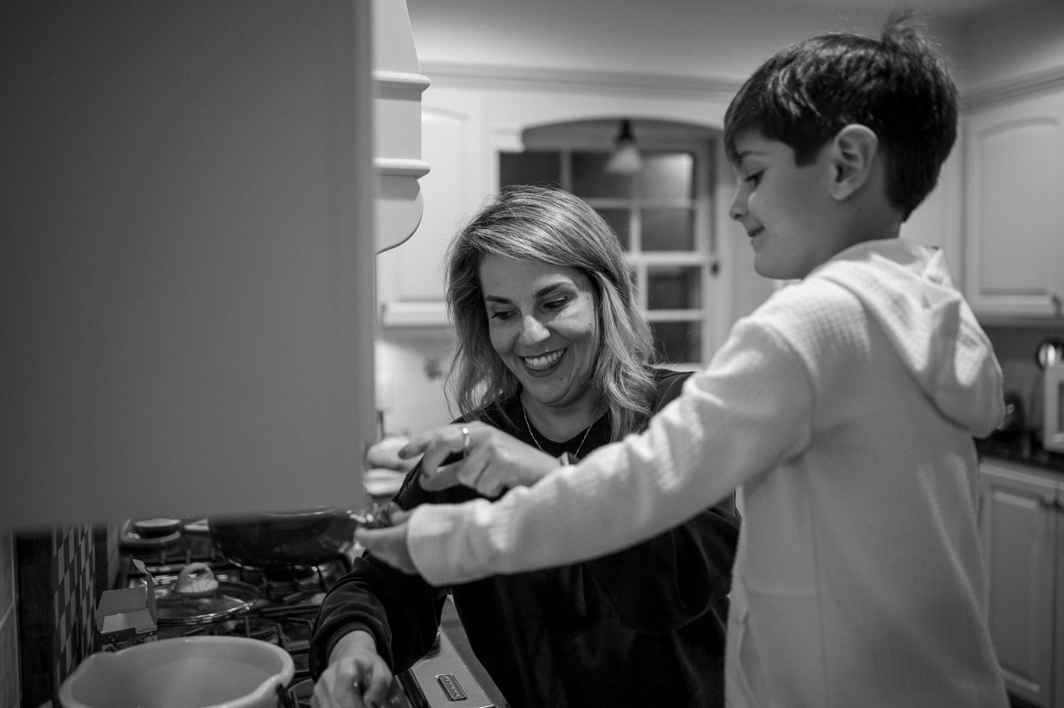A cozy kitchen scene showing two people preparing food together.