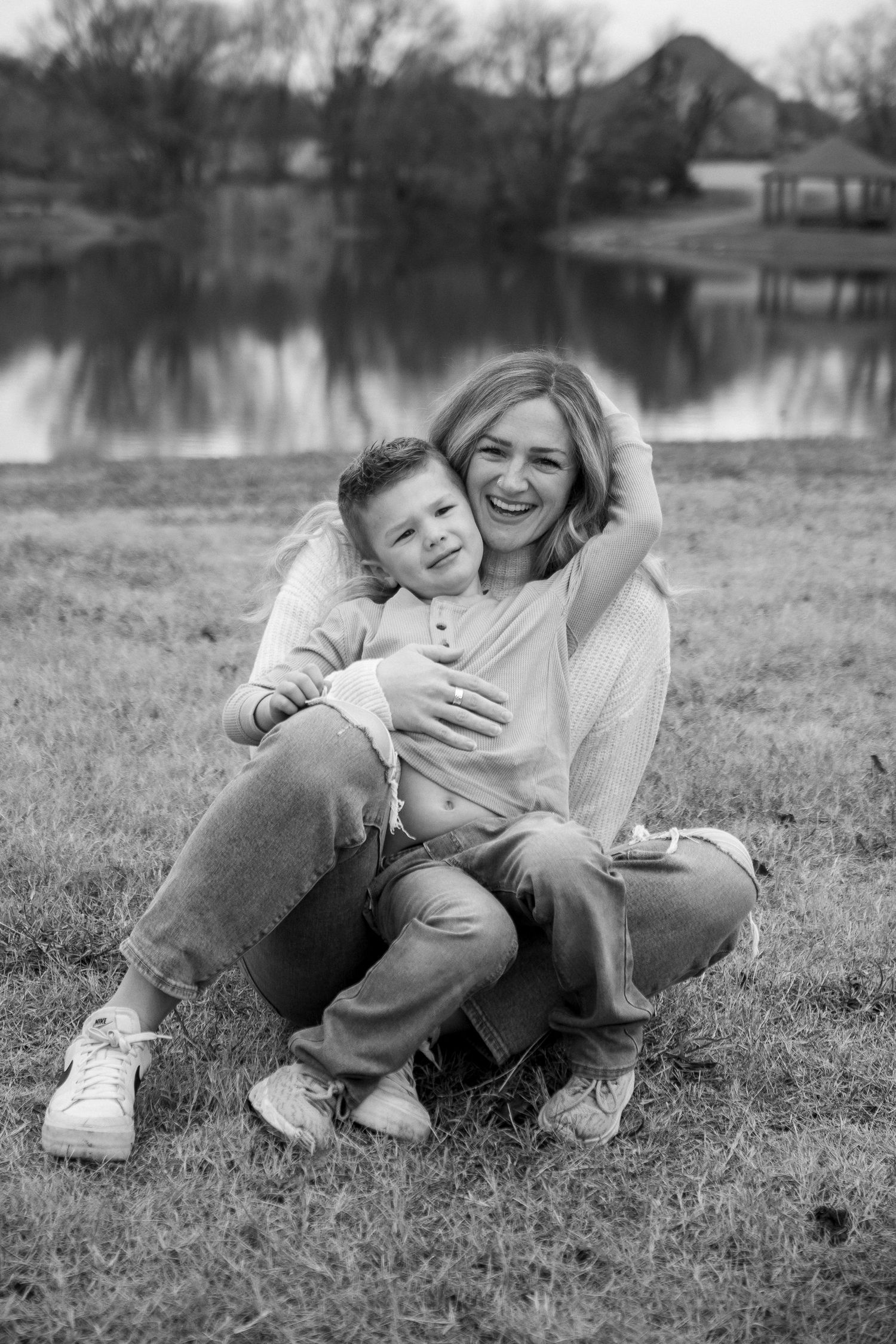 A joyful moment captured in black and white by a lake.