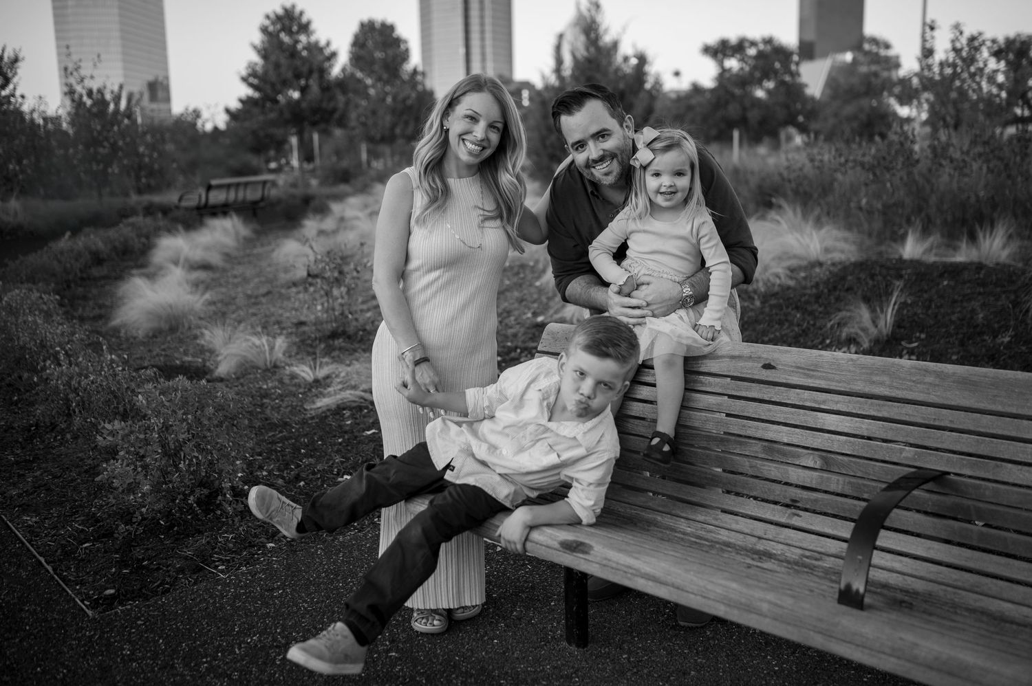 A family sharing joyful moments together while sitting on a wooden bench outdoors.