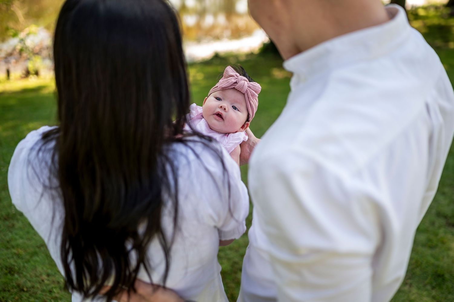 Close-up of family bonding moments outdoors in matching white outfits.