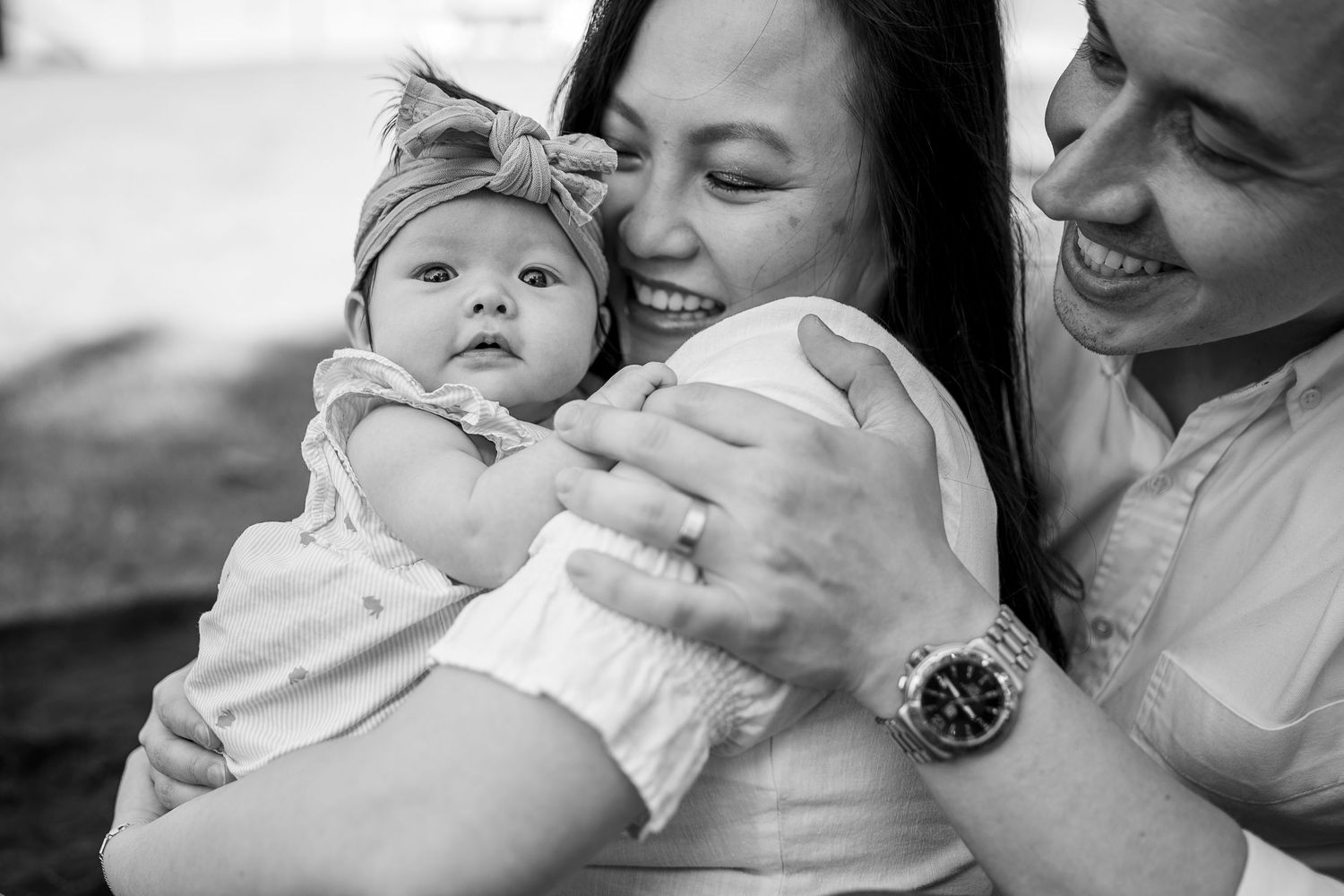 A tender black and white photo series showing intimate moments between a parent and baby in various loving poses.