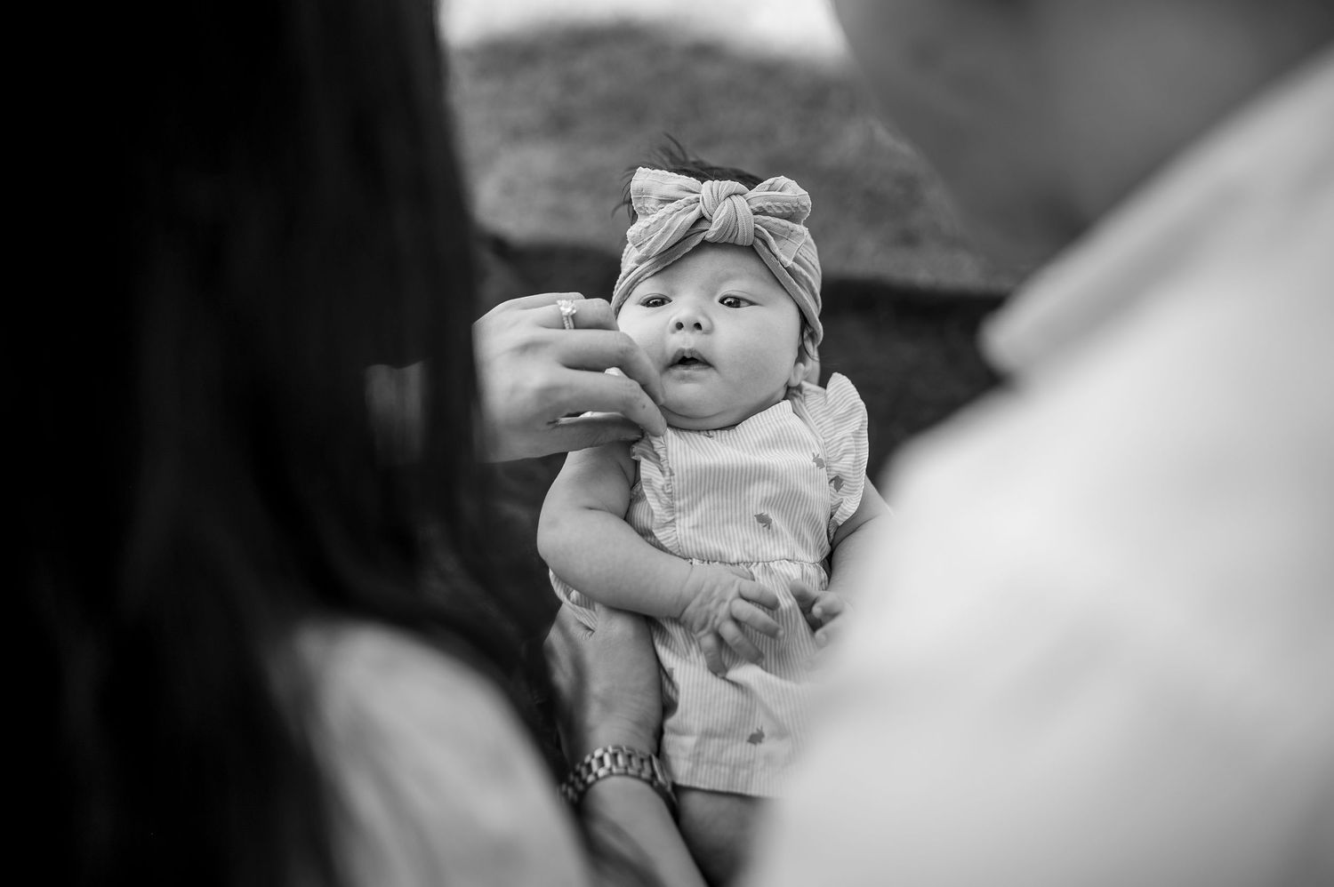 A collage of black and white close-up shots showing tender moments between parent and newborn baby.