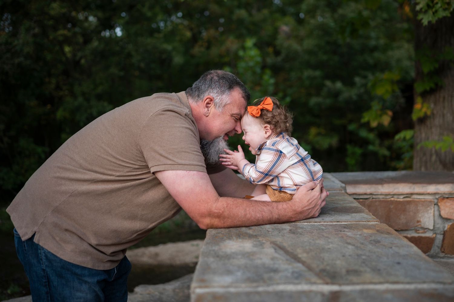 Sweet interaction captured between adult and toddler at a wooden park table.