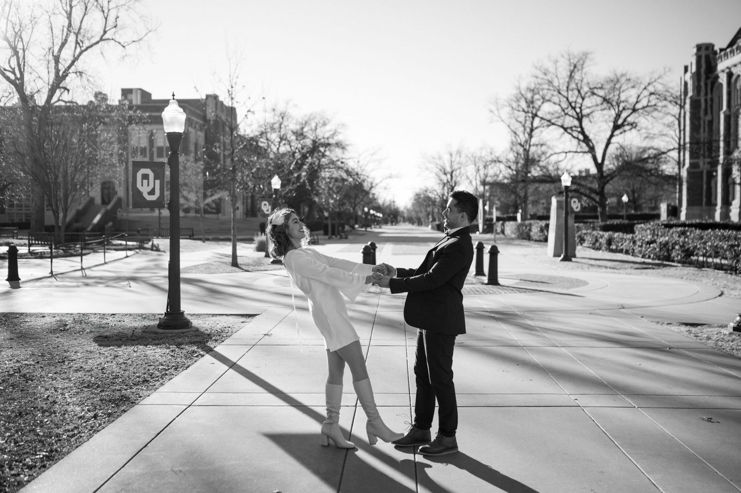 A black and white photo of figures standing together on a college campus pathway in winter.