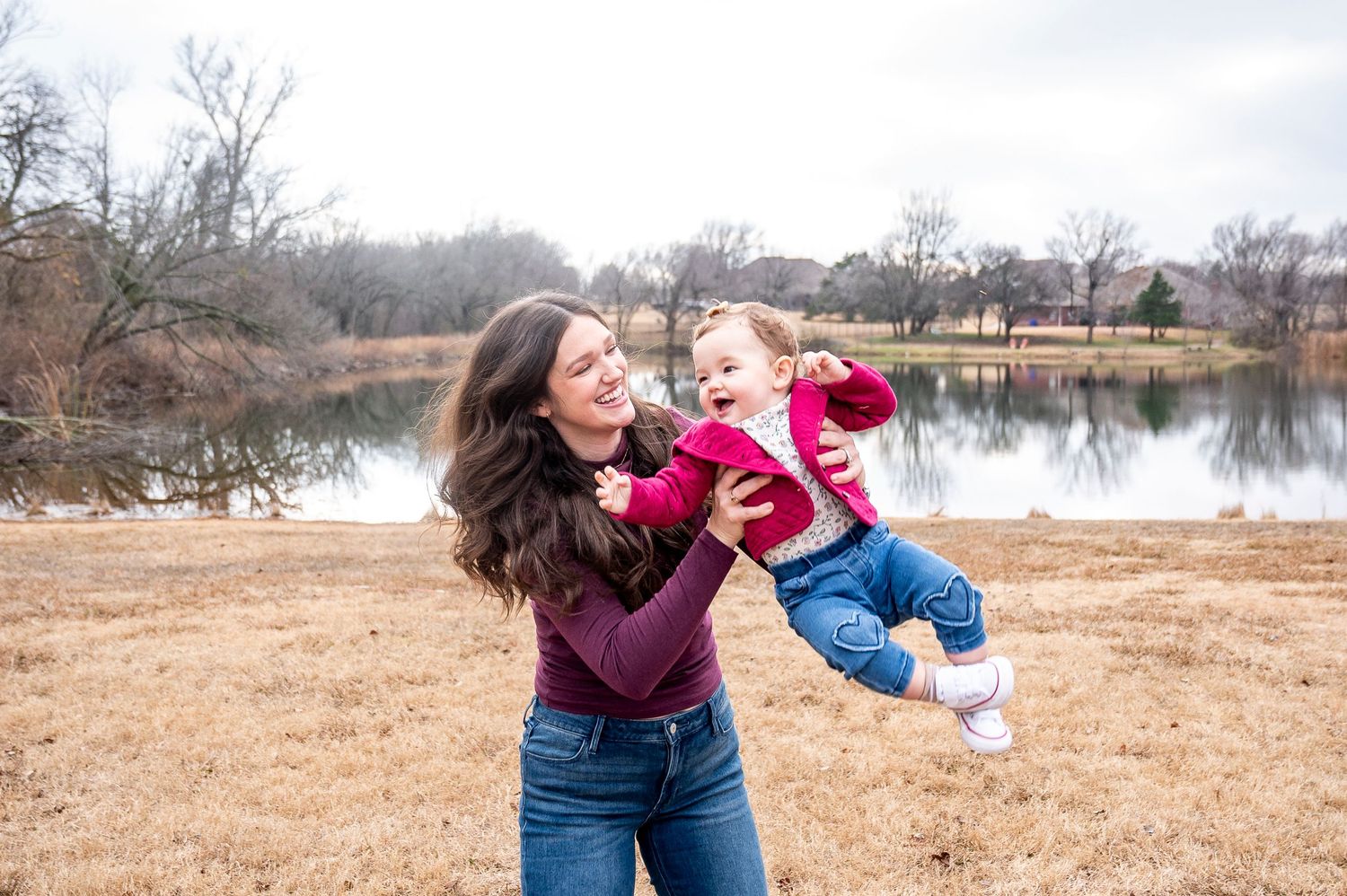 Playful moment captured between parent and child by a lakeside.