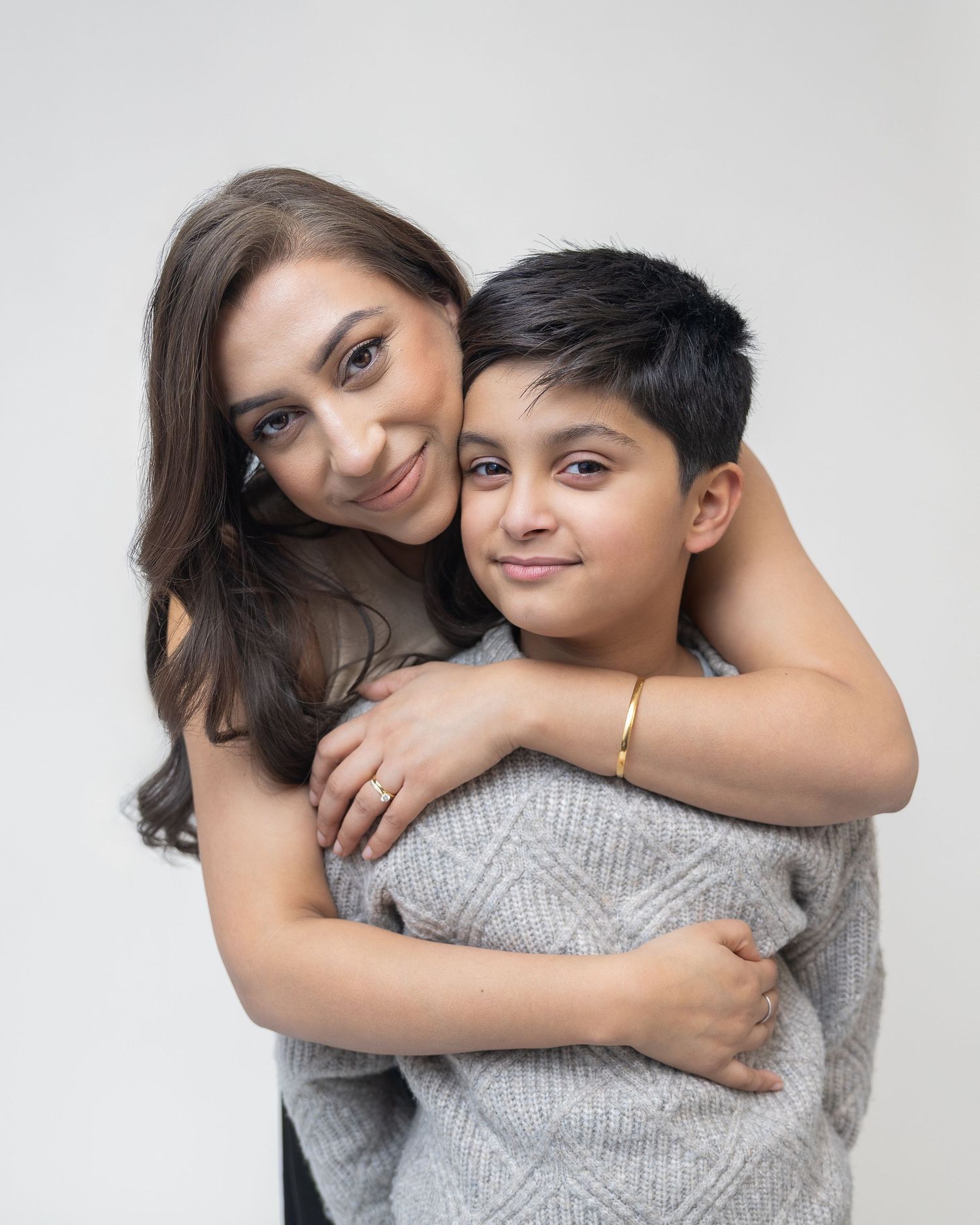 A warm embrace between two people wearing gray sweaters shown from multiple angles in a photo collage.