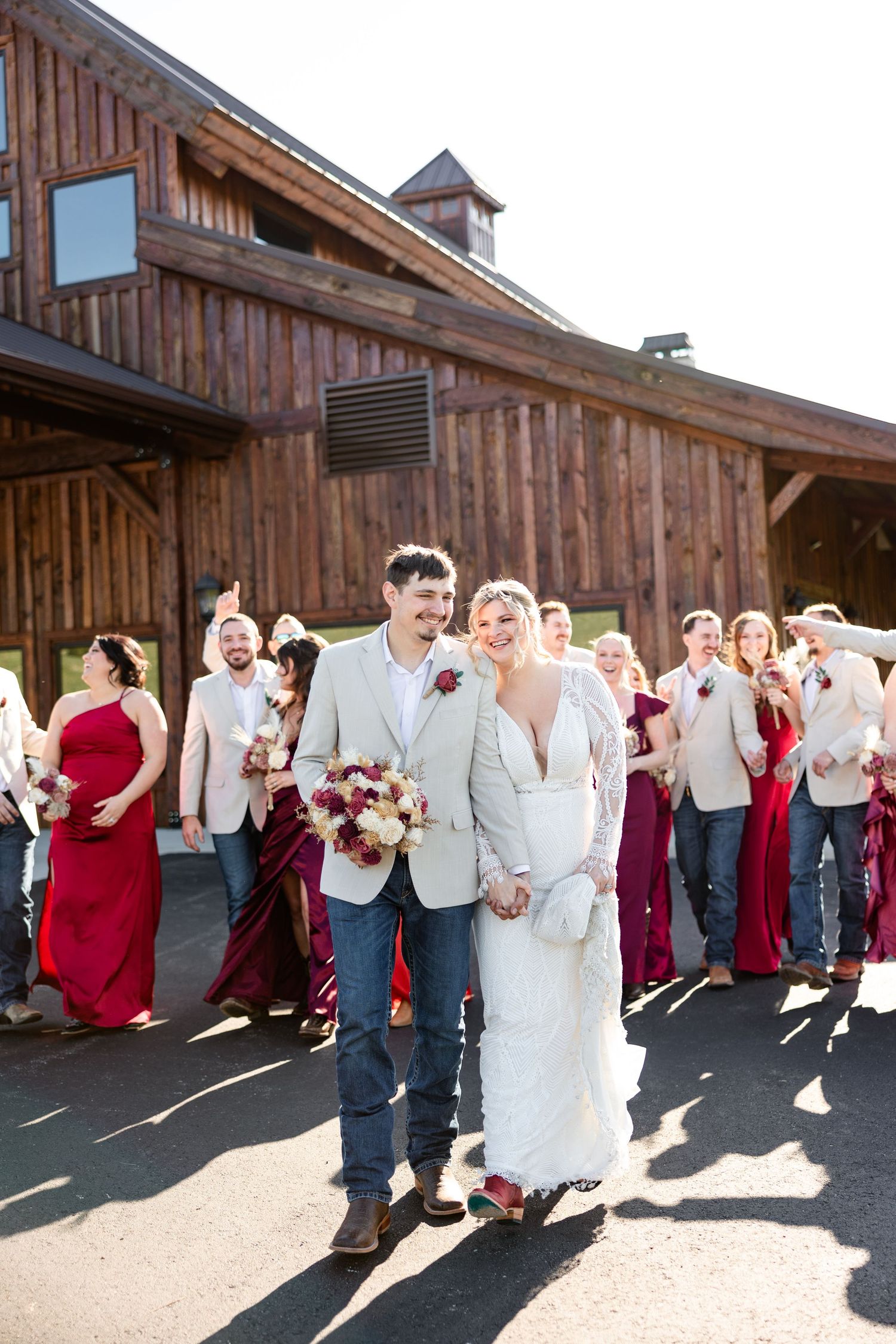 Wedding party celebrates outside Hanover Reserve wedding venue with bride in white gown and groom in tan suit.