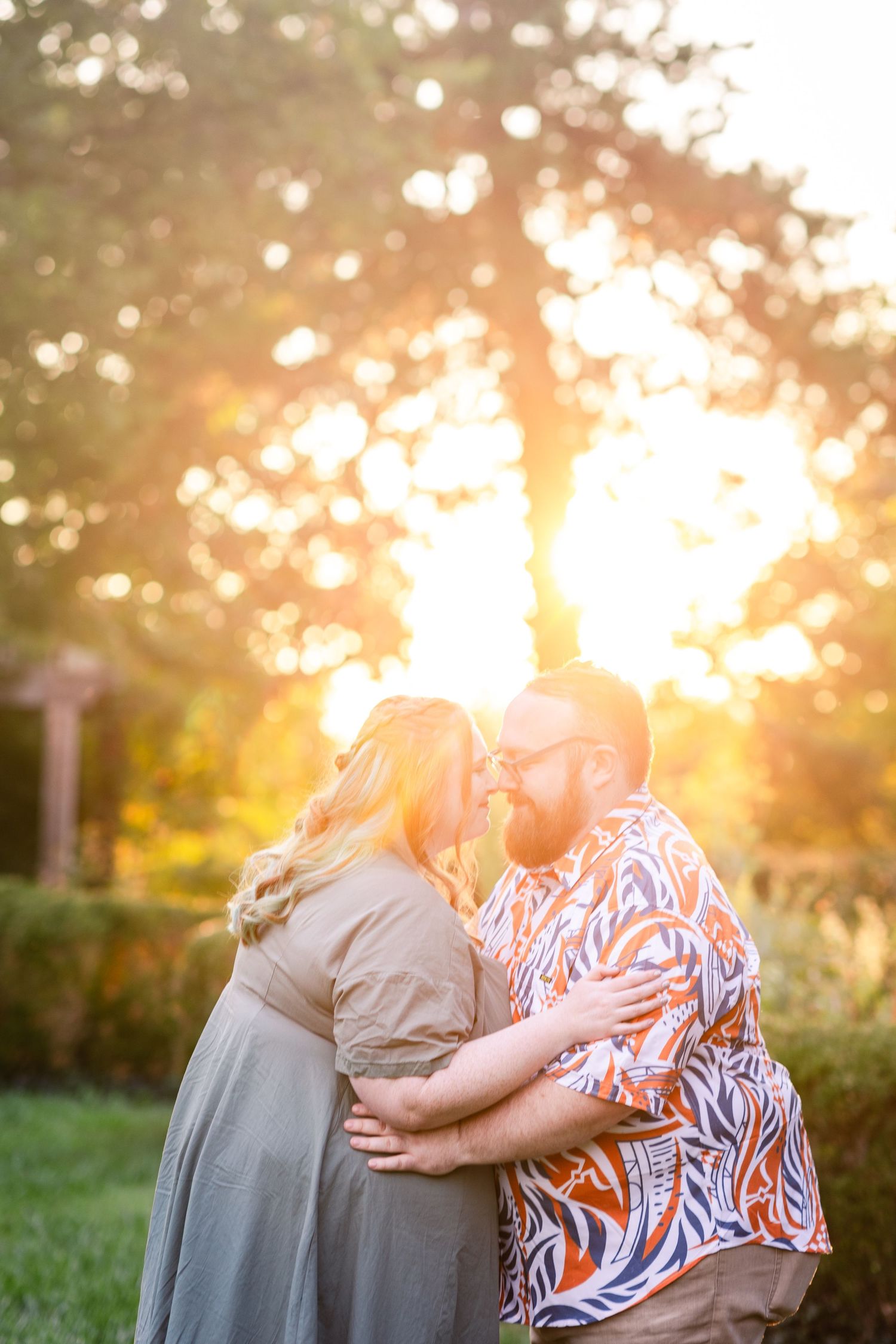 Romantic couple embracing near kissing with stunning golden sunset bokeh background.