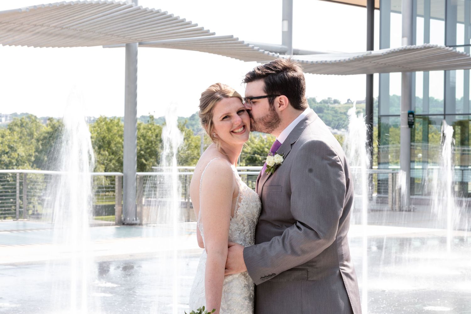 Bride and groom share a romantic moment near fountains outside a Cincinnati wedding venue.