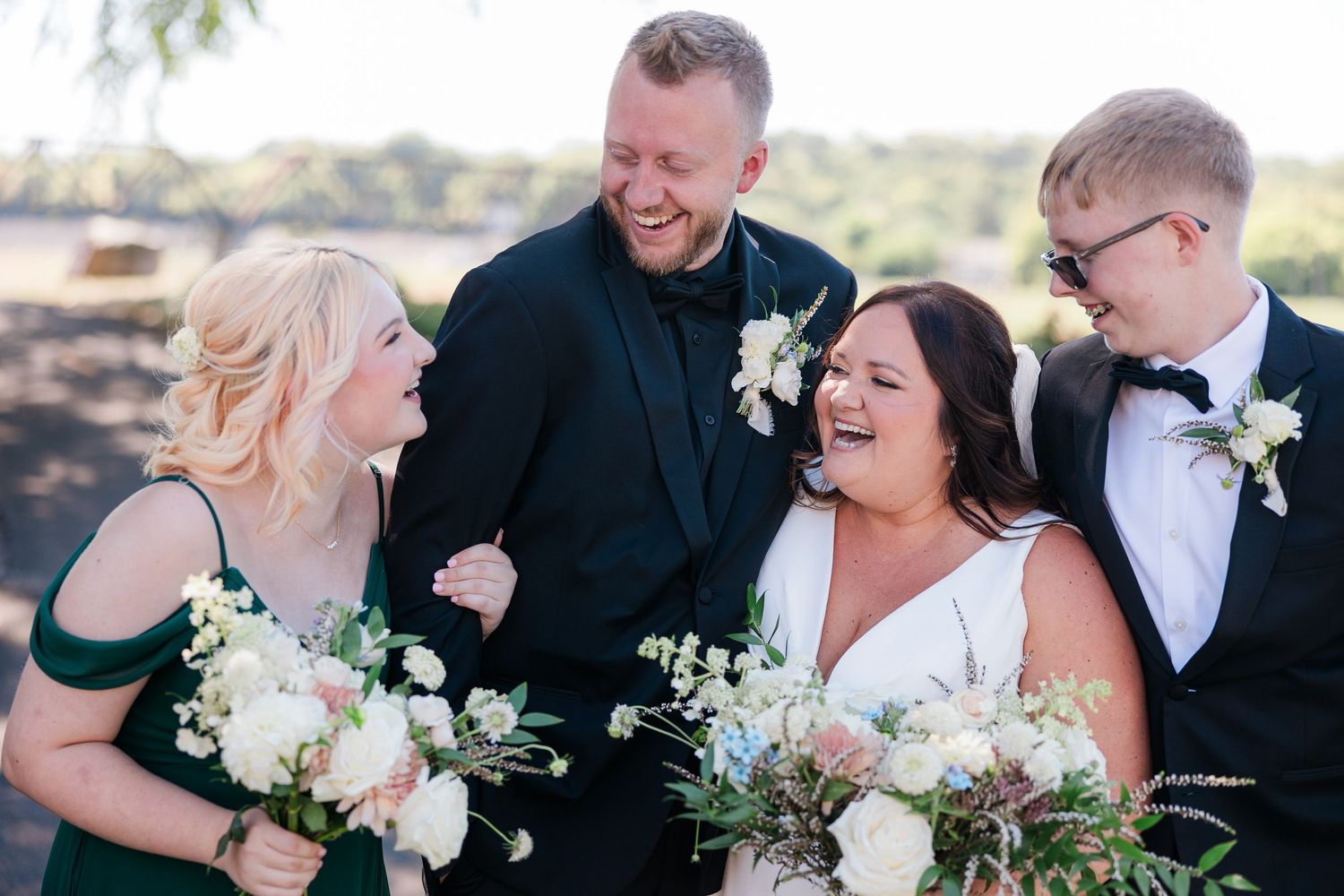 Bride and groom laugh with their kids.