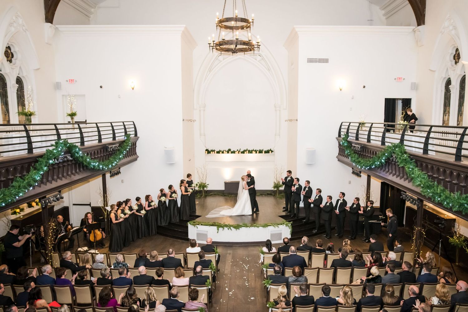 Elegant church wedding ceremony with couple at altar, choir, floral garlands on balconies, and seated guests at the transept in cincinnati.