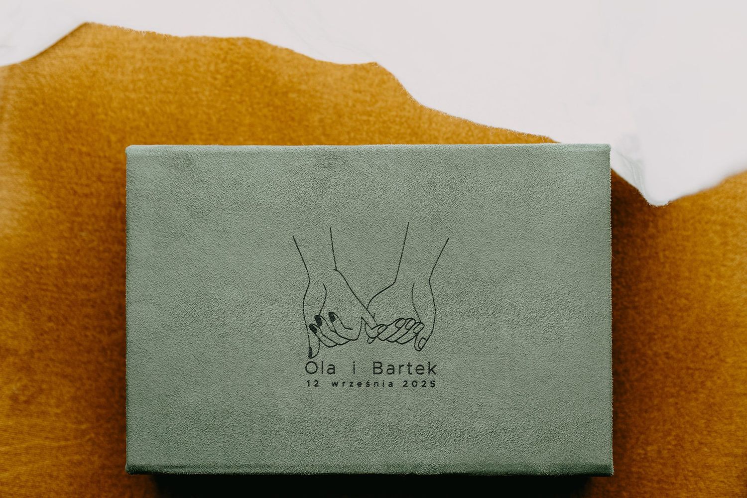 Sage green velvet wedding box engraved with holding hands illustration for Ola i Bartek.