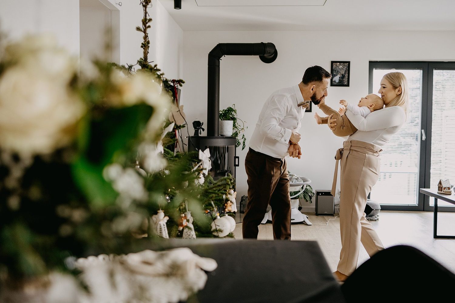 A man dances with an older woman in a decorated home during a christening celebration.